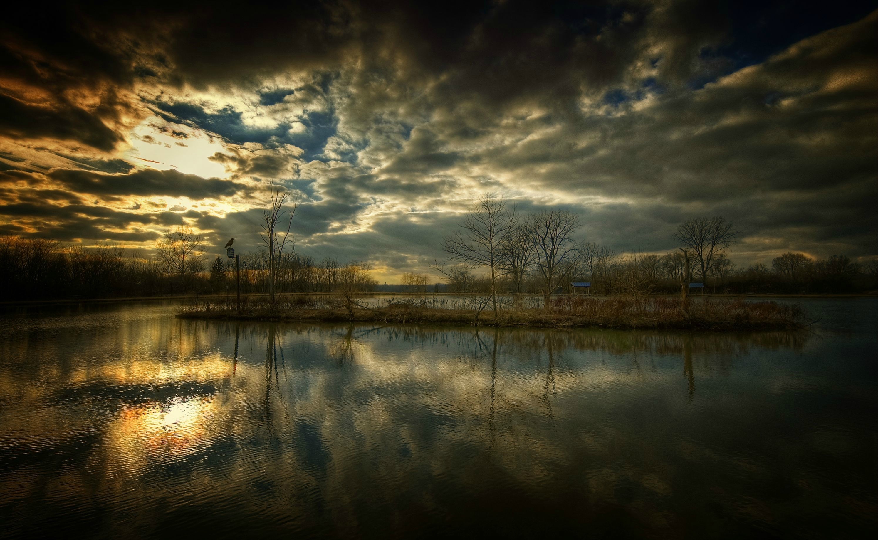 Dramatic sunset over a calm lake with reflections HD Wallpaper