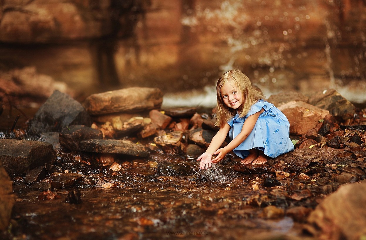 Girl playing in a stream with rocks HD Wallpaper