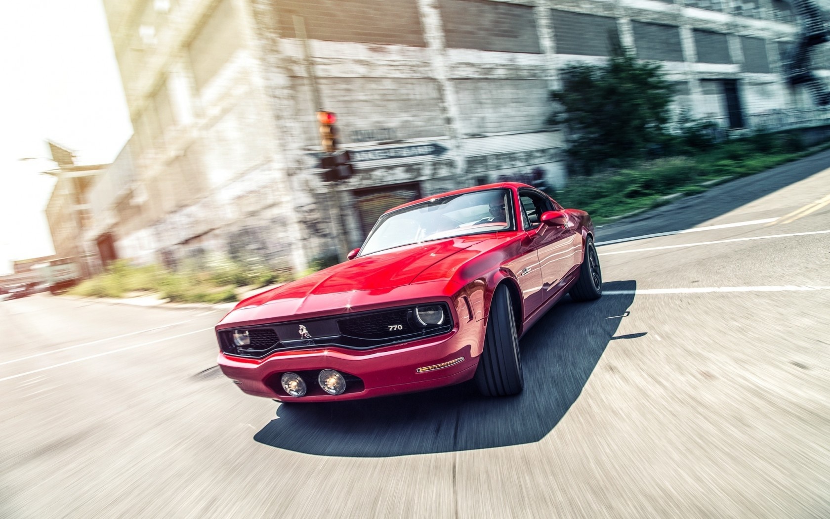 Red classic muscle car driving on a street HD Wallpaper