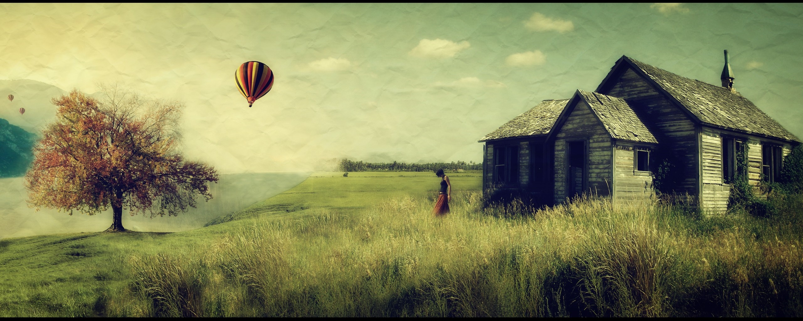 Hot air balloons over a rural landscape with an abandoned cabin and tree HD Wallpaper