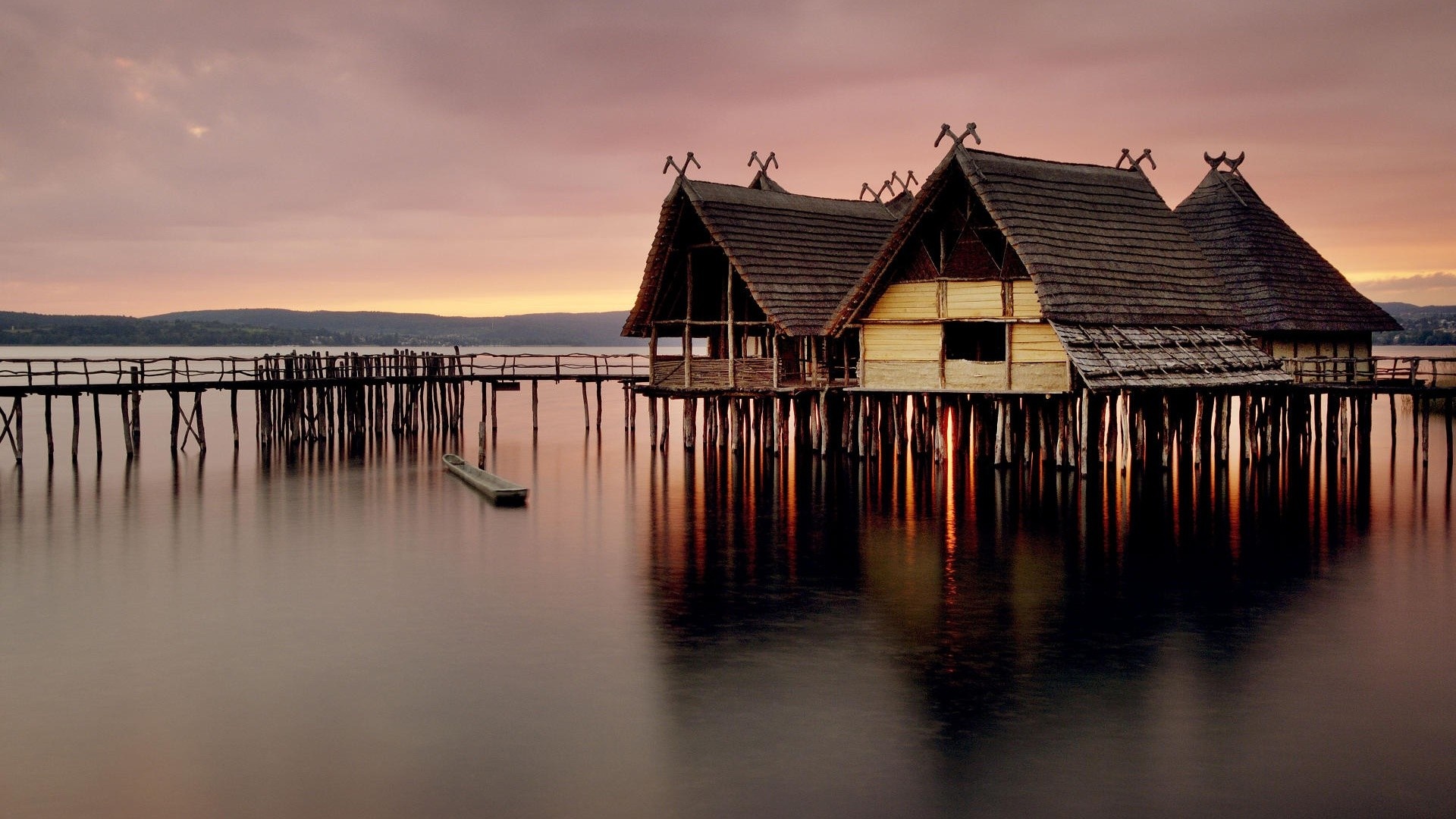 Stilt houses on a lake at sunset with a pier HD Wallpaper