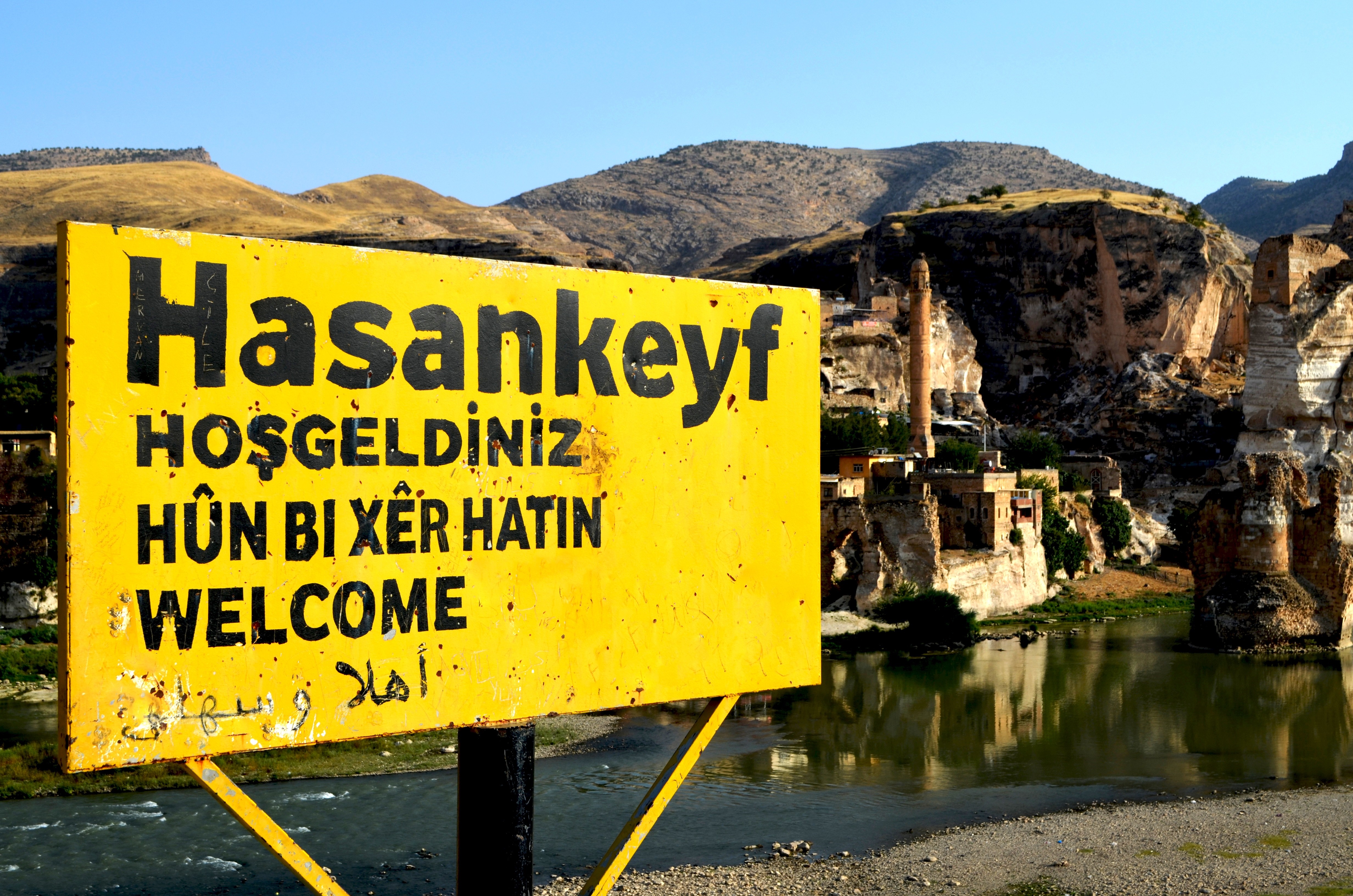 Hasankeyf welcome sign with ancient city in background HD Wallpaper
