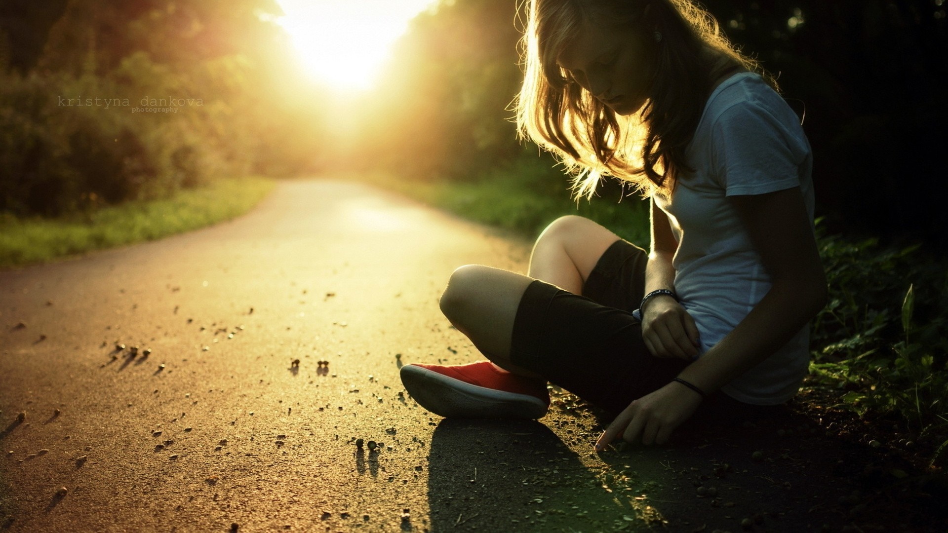Woman sitting on a road during sunset HD Wallpaper