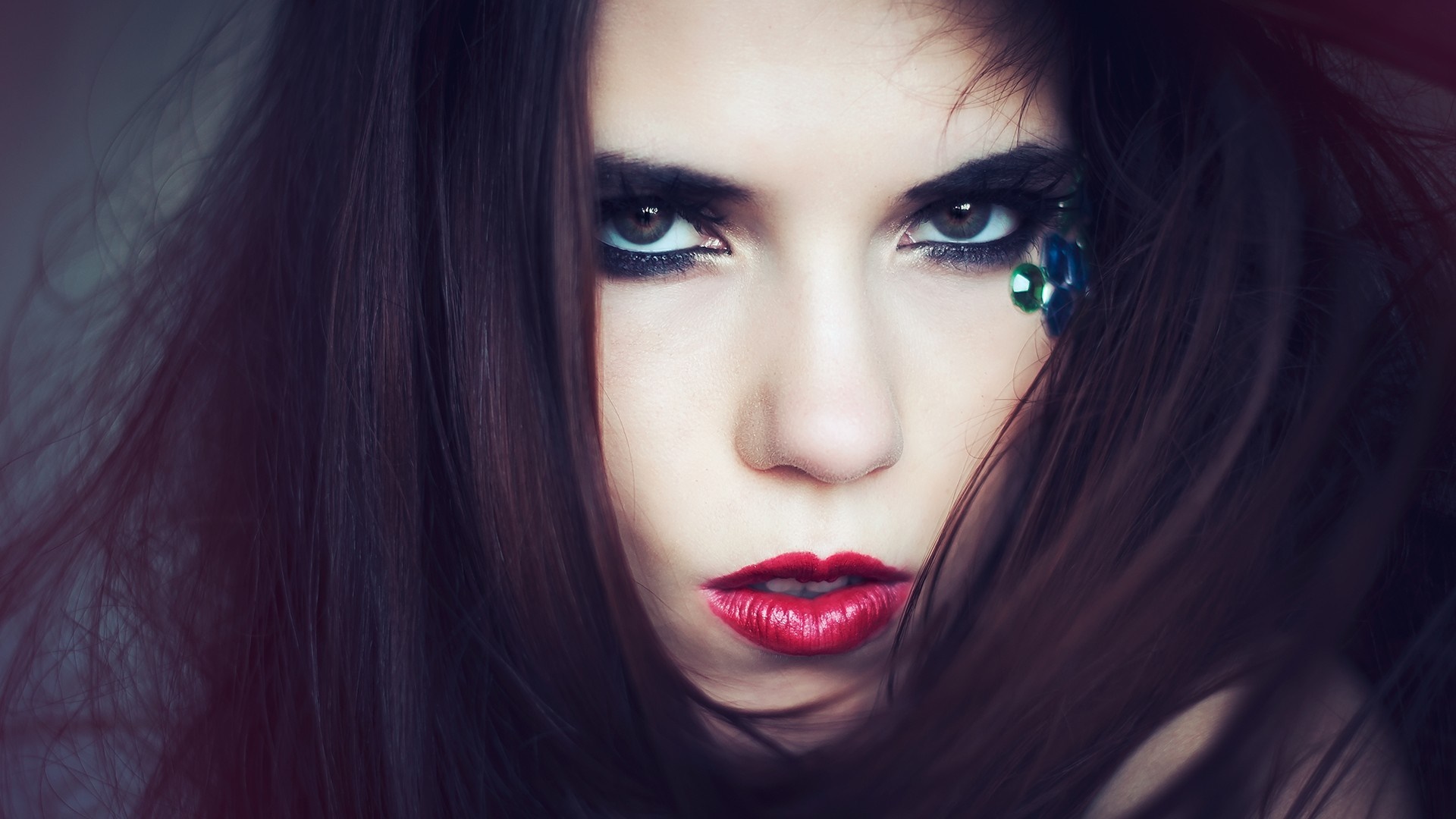 Woman with dark hair and dramatic makeup HD Wallpaper