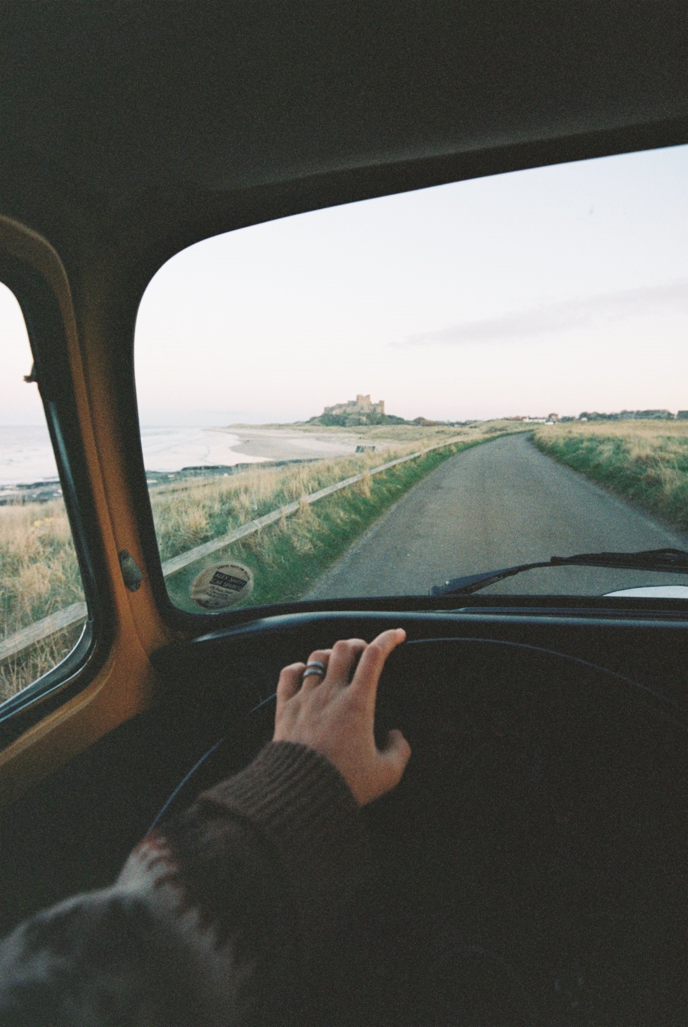 Driving towards a castle by the sea HD Phone Wallpaper