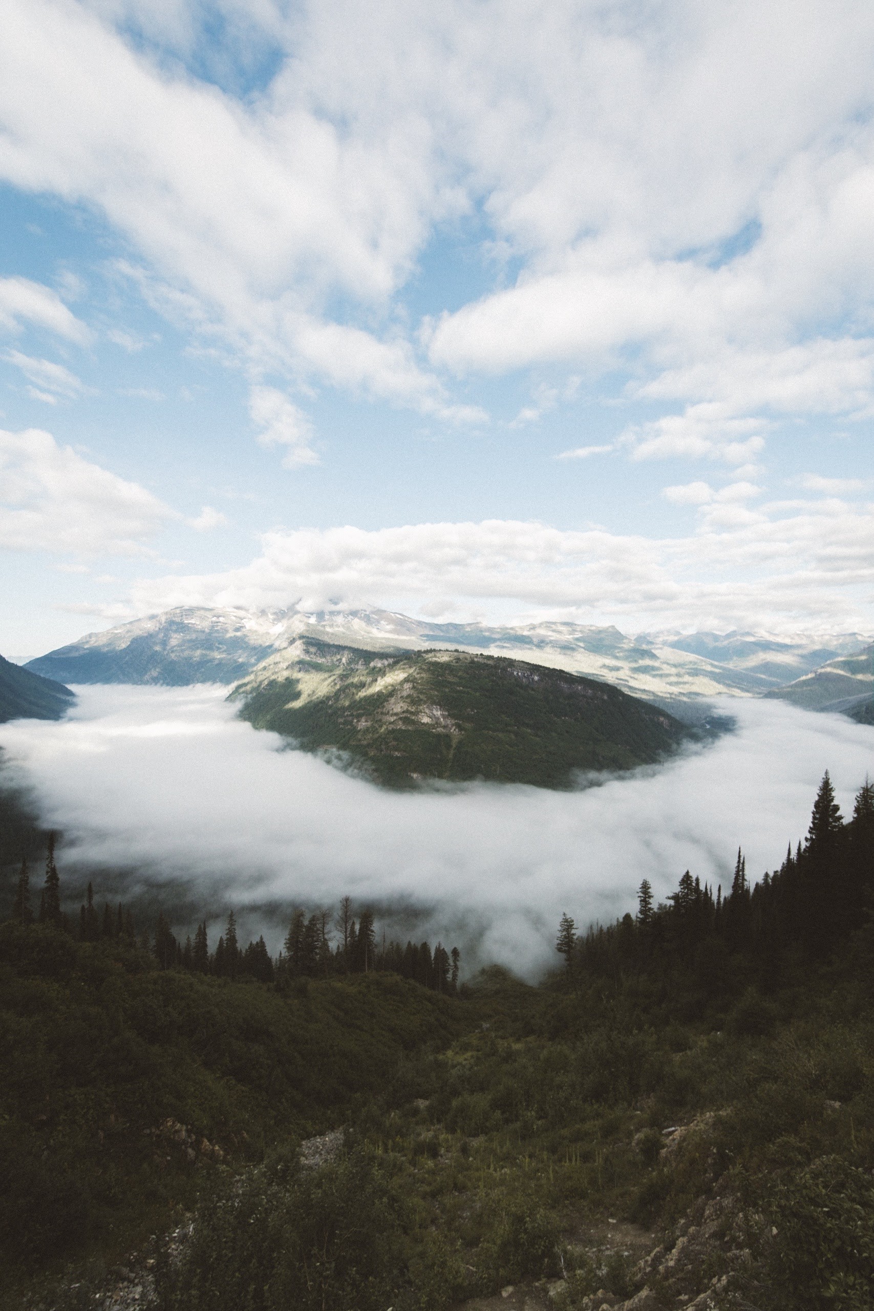 Mountains covered in fog with clouds in the sky HD Phone Wallpaper