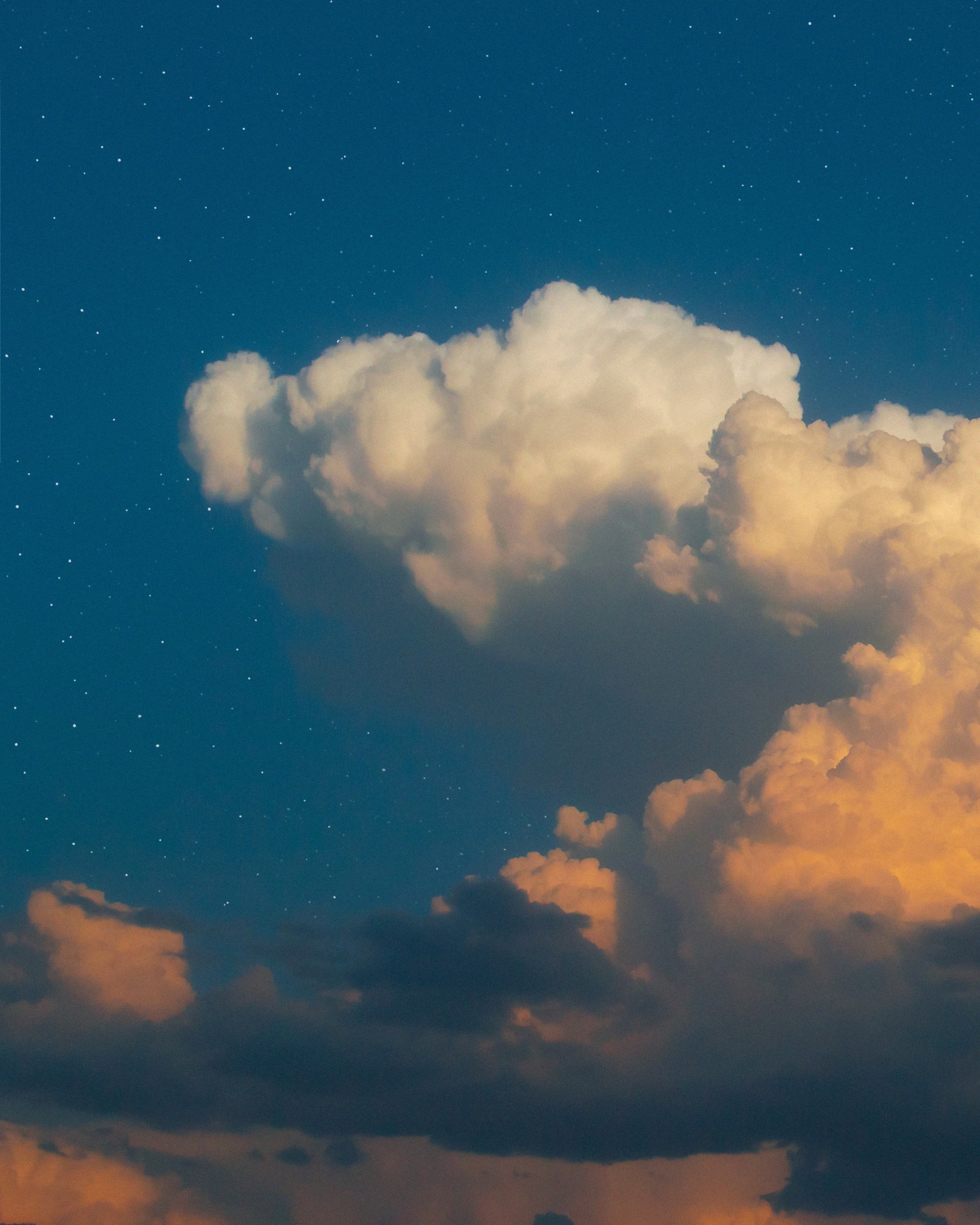 Clouds illuminated by sunlight against a starry blue sky HD Phone Wallpaper