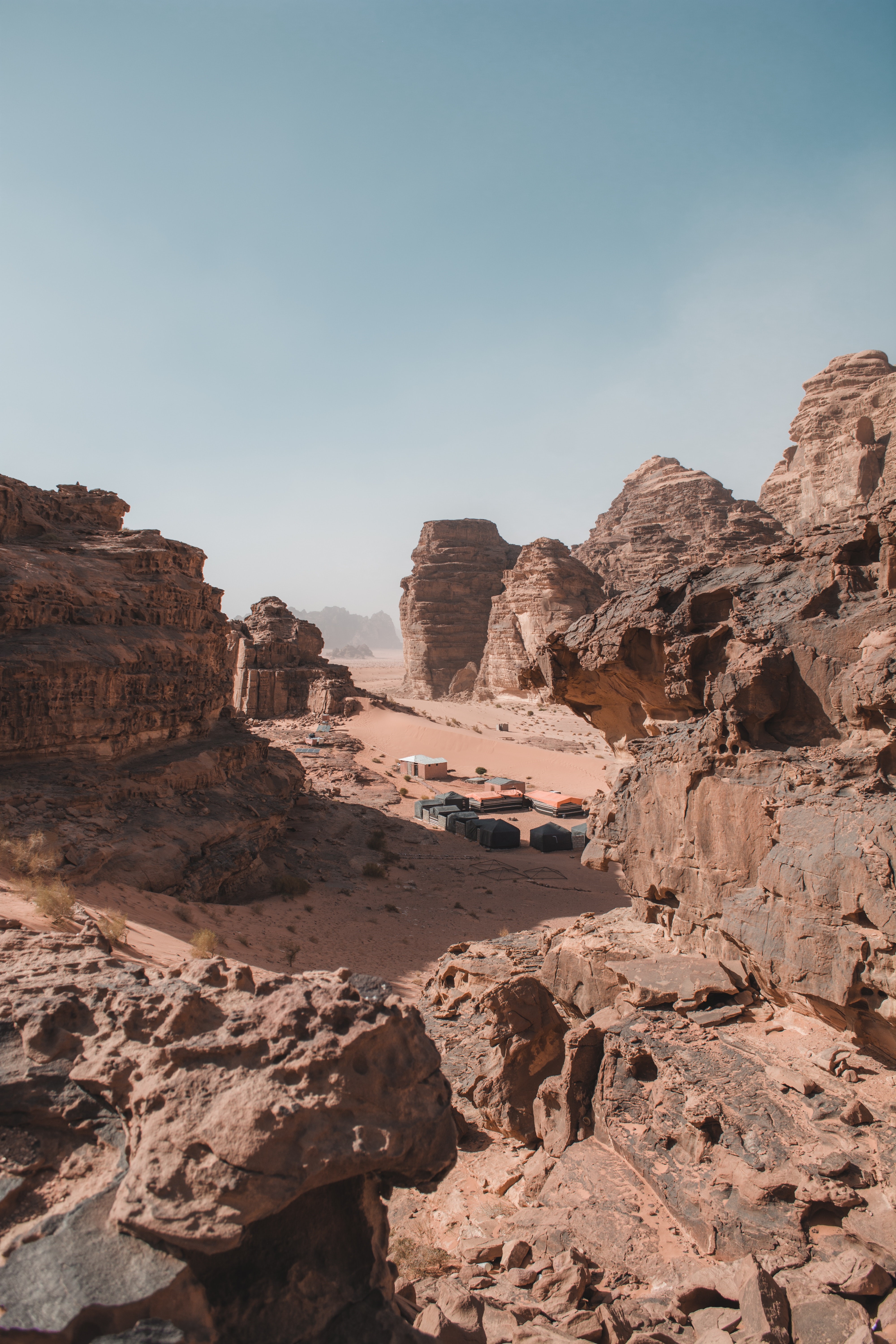 Desert landscape with rock formations and tents HD Phone Wallpaper