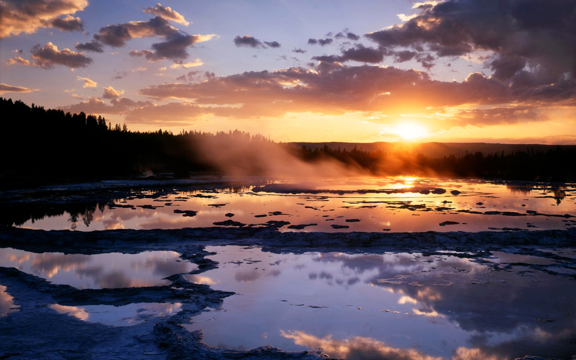 Sunset over a steaming geothermal pool with reflections HD Wallpaper