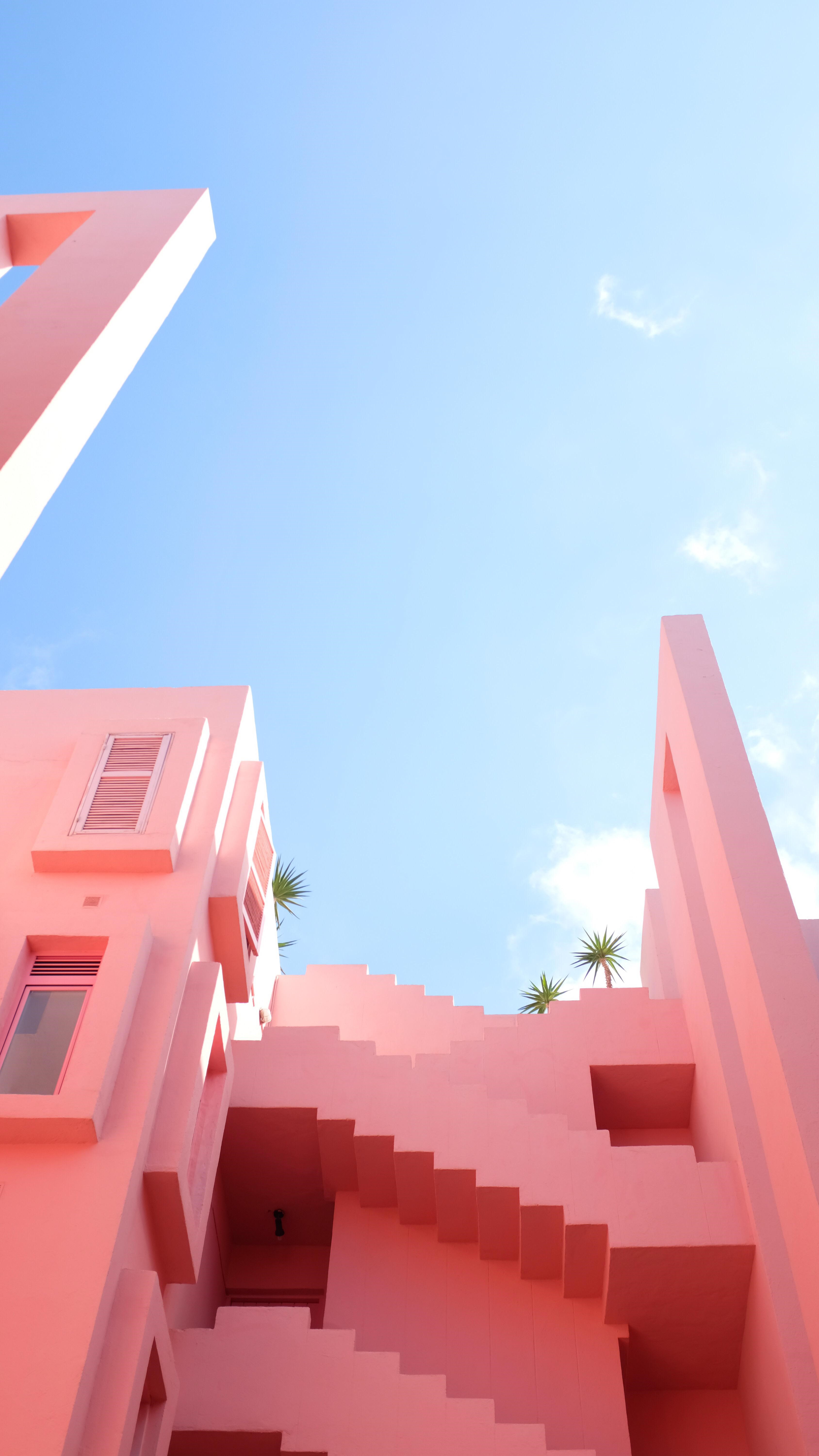 Pink building with stairs and palm trees against blue sky HD Phone Wallpaper