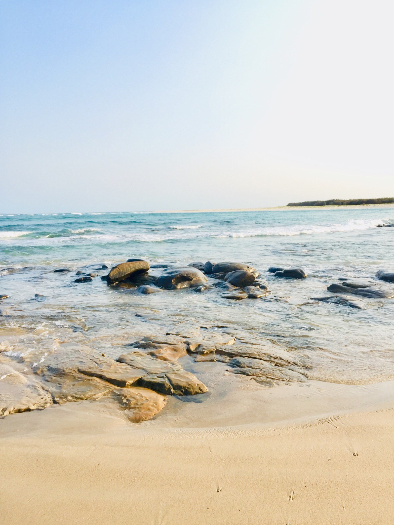 Rocks on a sandy beach with ocean waves HD Phone Wallpaper