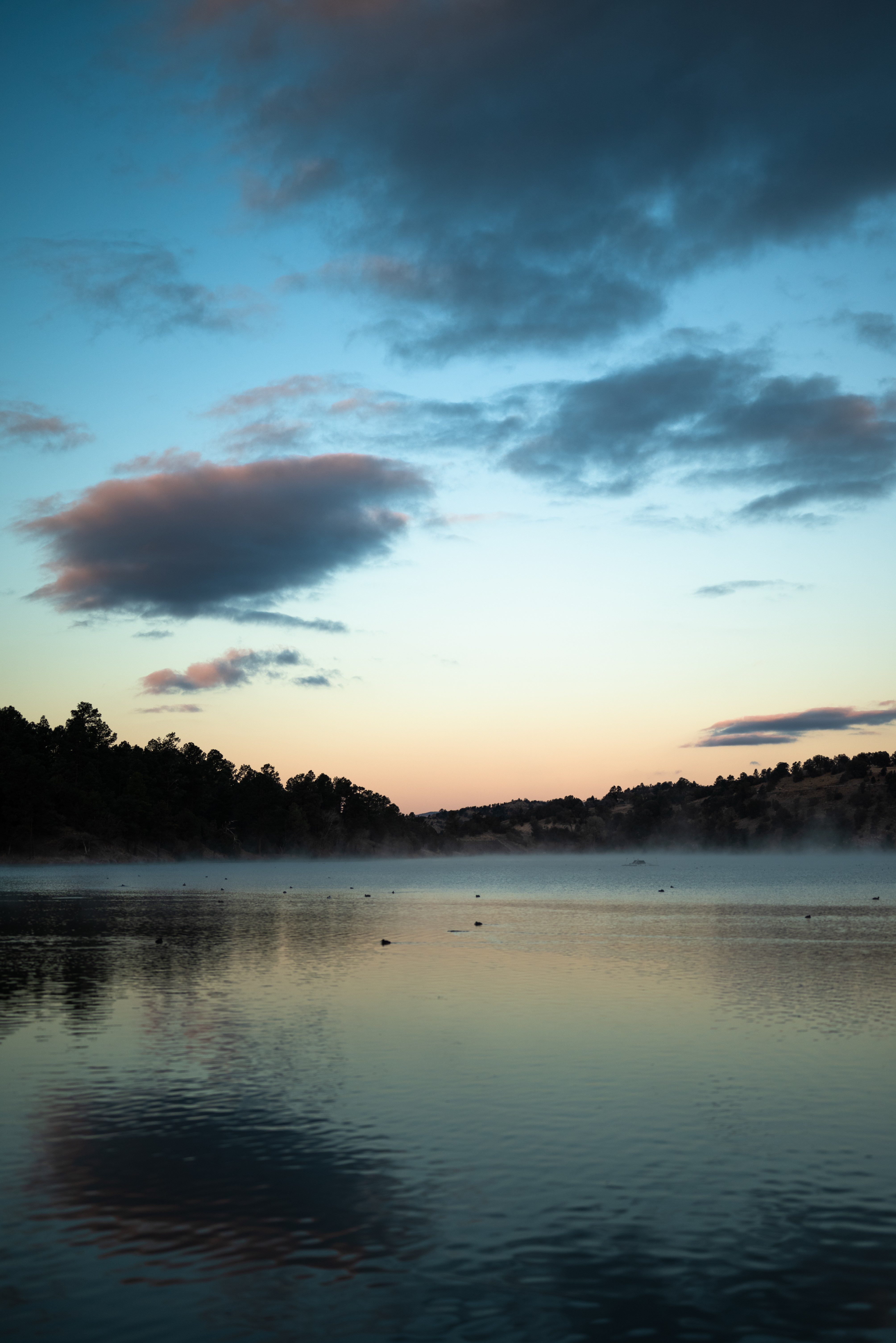Misty lake at sunrise with dark clouds HD Phone Wallpaper