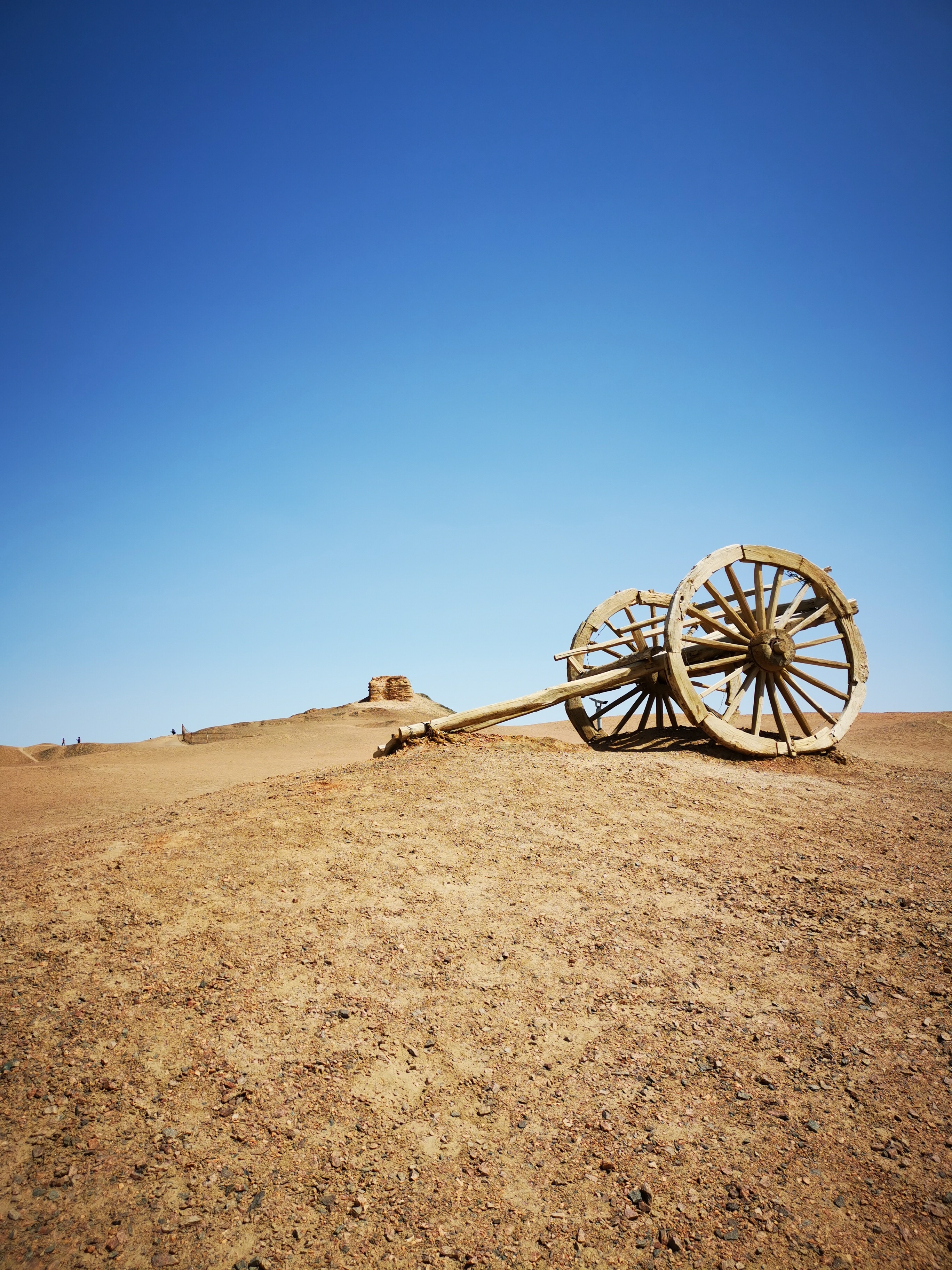 Ancient wooden cart on a desert hill under blue sky HD Phone Wallpaper