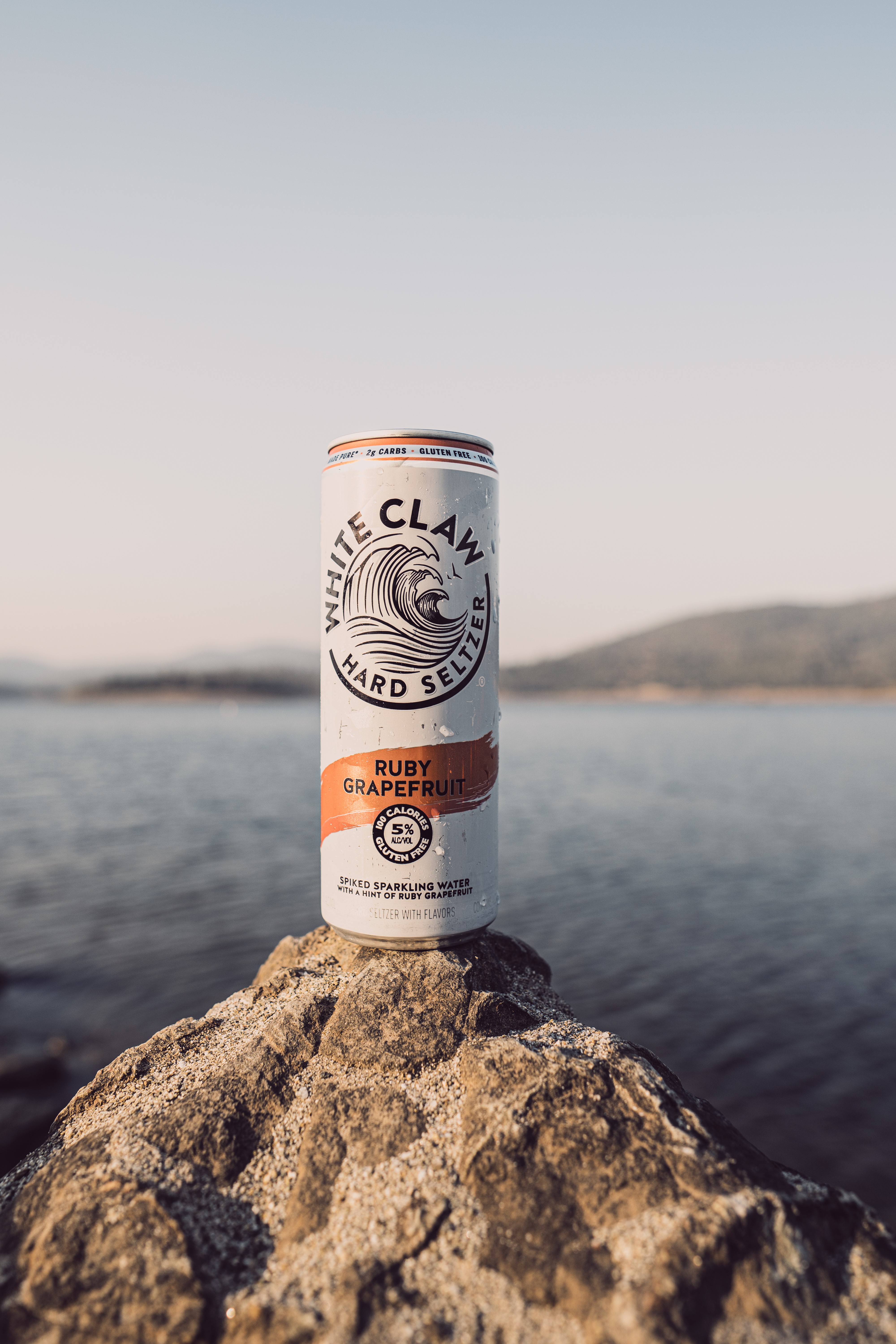 White Claw Hard Seltzer Ruby Grapefruit can on rock HD Phone Wallpaper