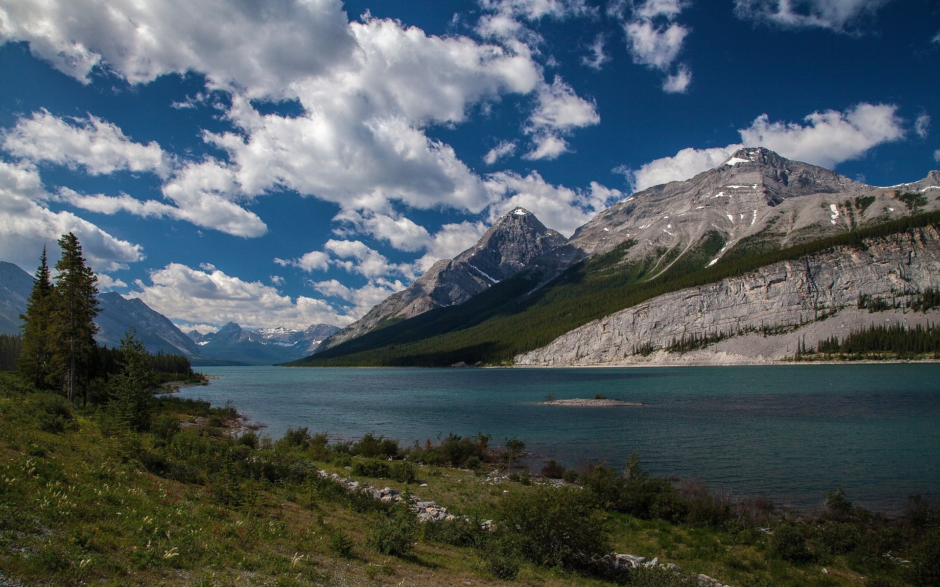 Turquoise lake and mountains under a cloudy sky HD Wallpaper
