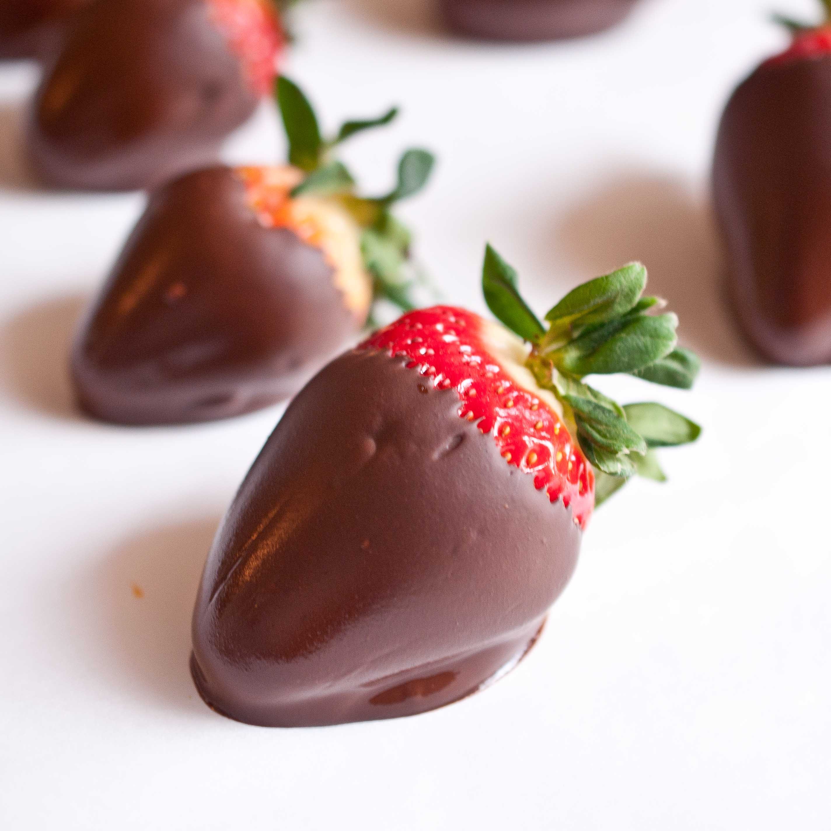 Chocolate-dipped strawberries on a white surface HD Wallpaper