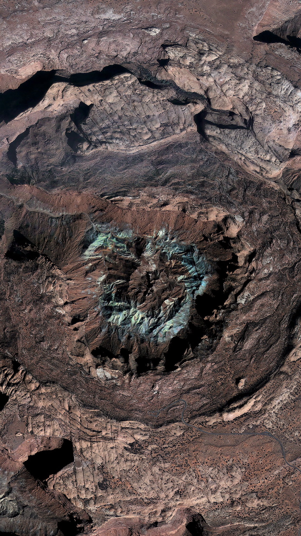 Aerial view of a crater with colorful mineral deposits HD Phone Wallpaper