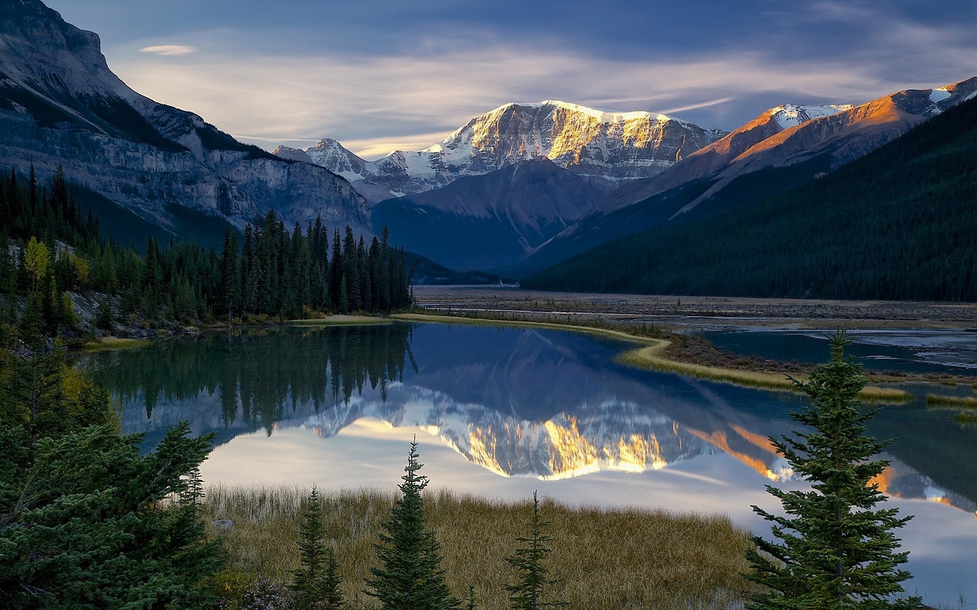 Mountain range reflected in a calm lake at sunset HD Wallpaper