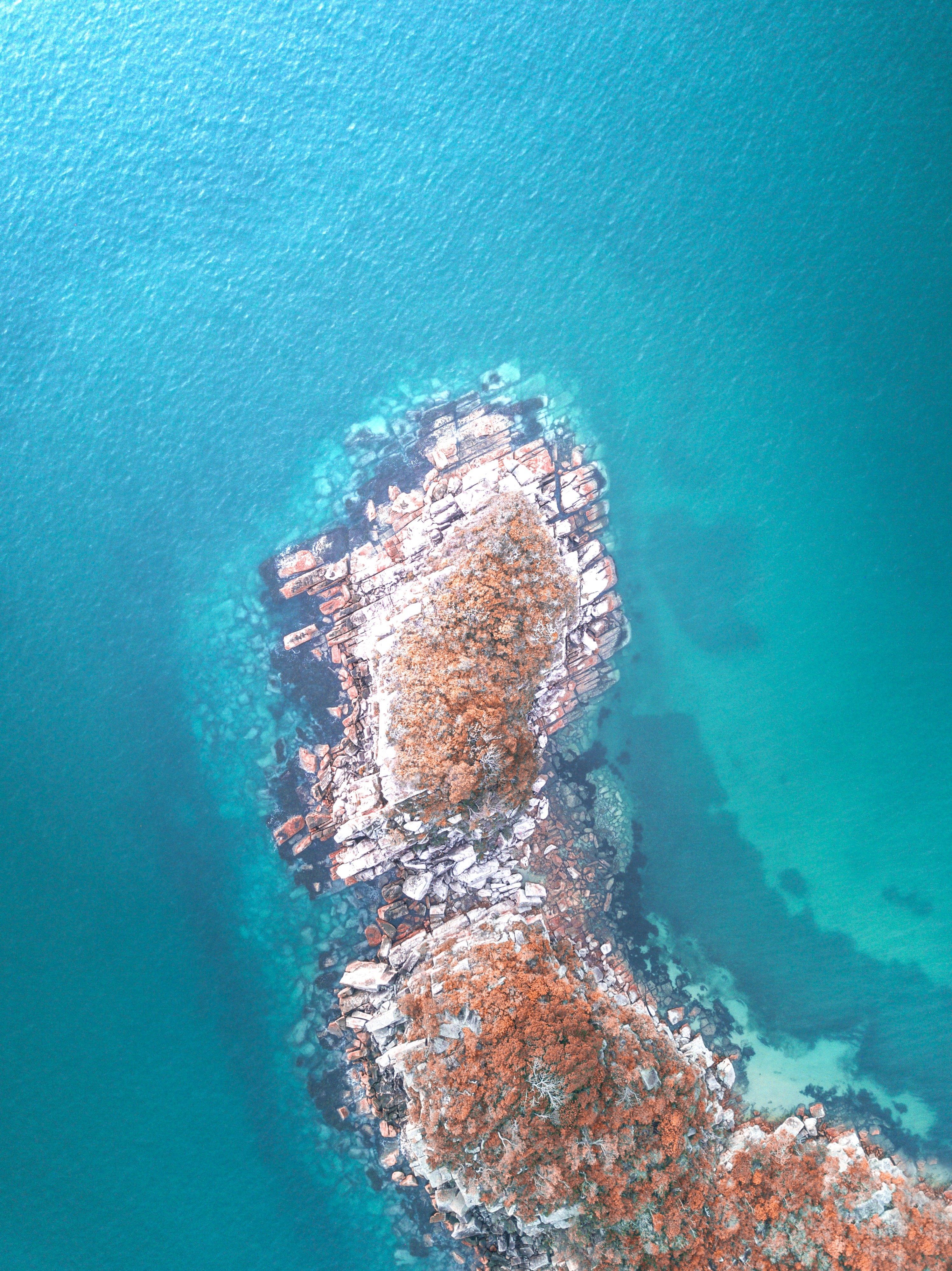 Aerial view of rocky island in turquoise water HD Phone Wallpaper