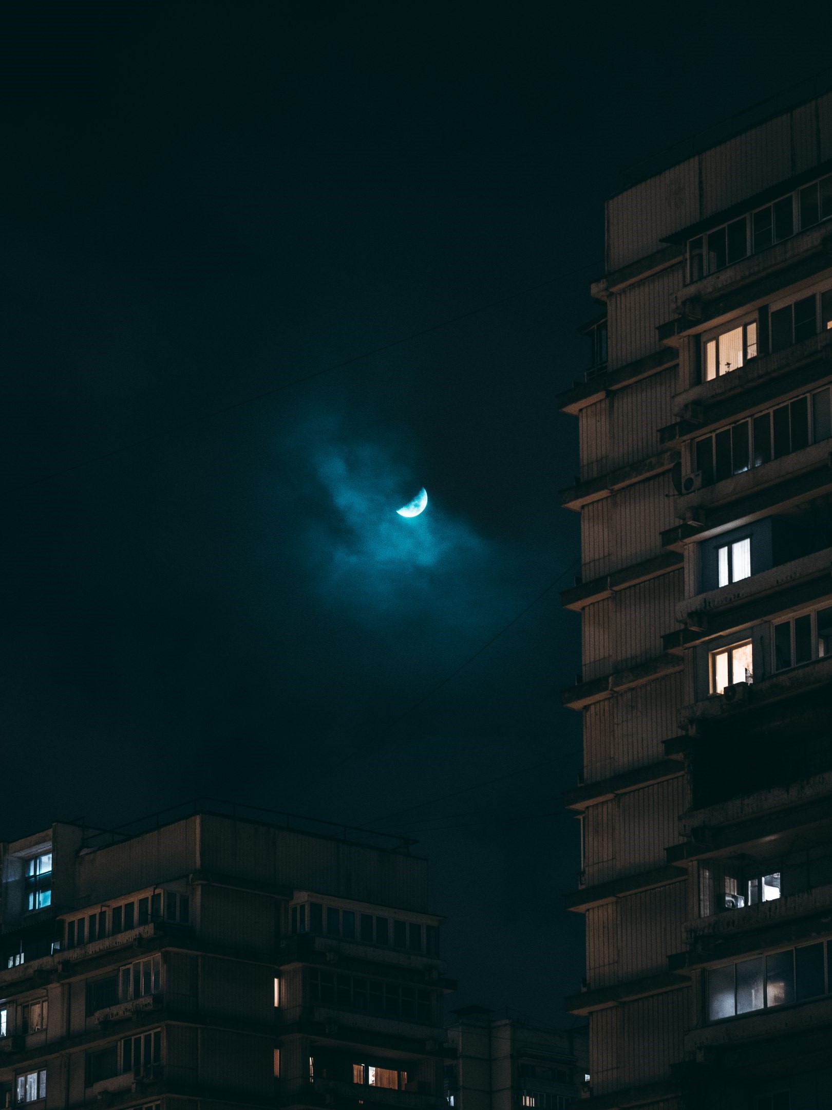 Crescent moon over city buildings at night HD Phone Wallpaper