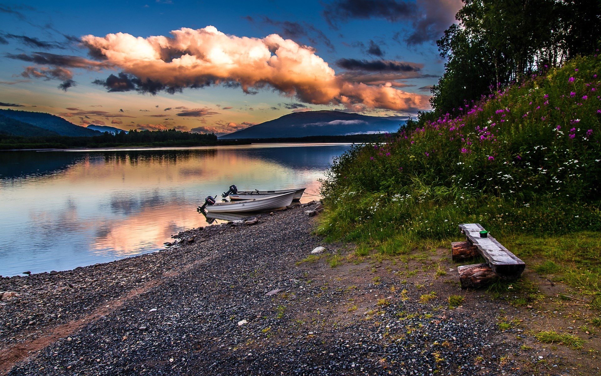 Boats on a lake shore with mountains and sunset clouds HD Wallpaper