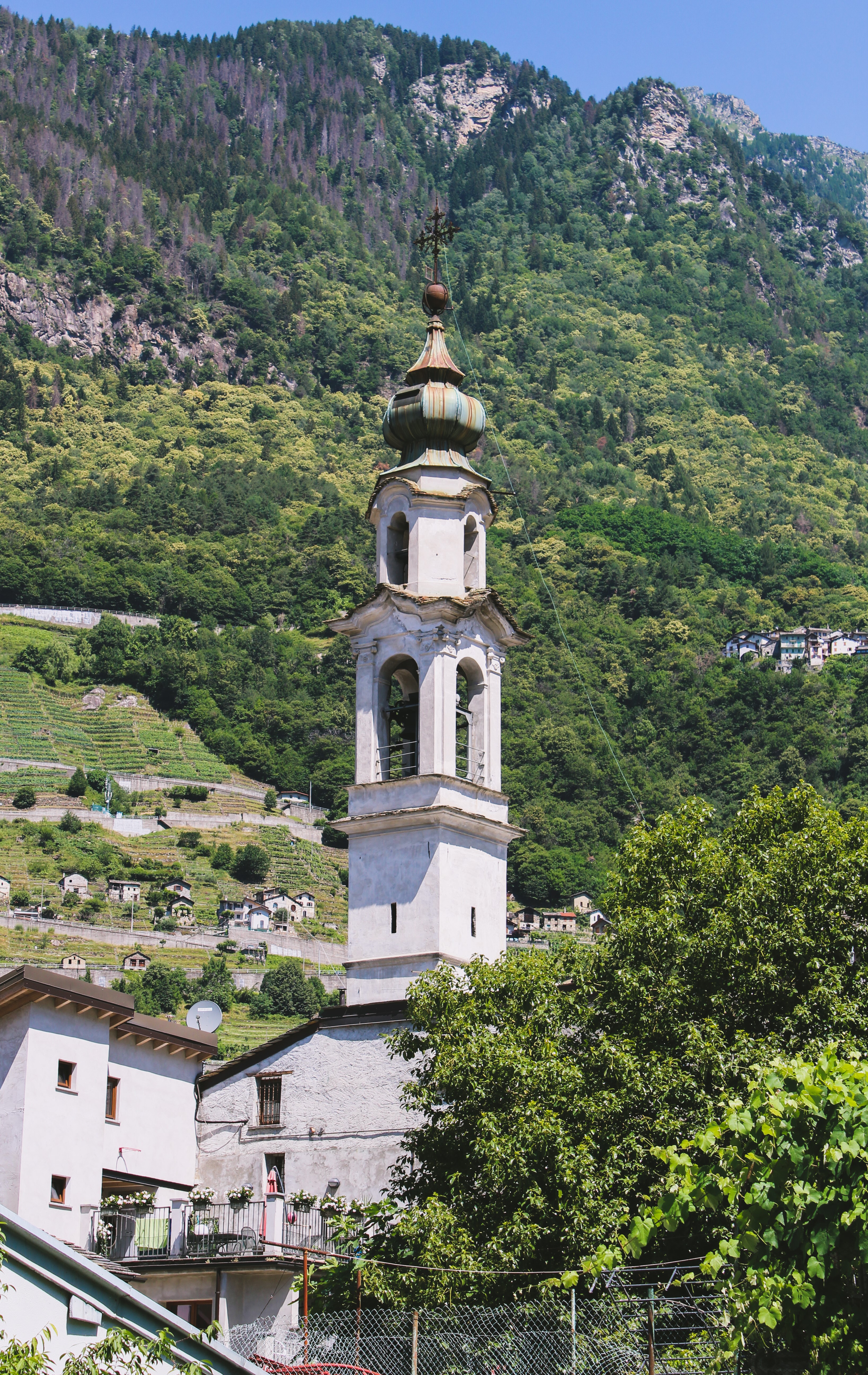 Church bell tower in a mountain village, Italy HD Phone Wallpaper