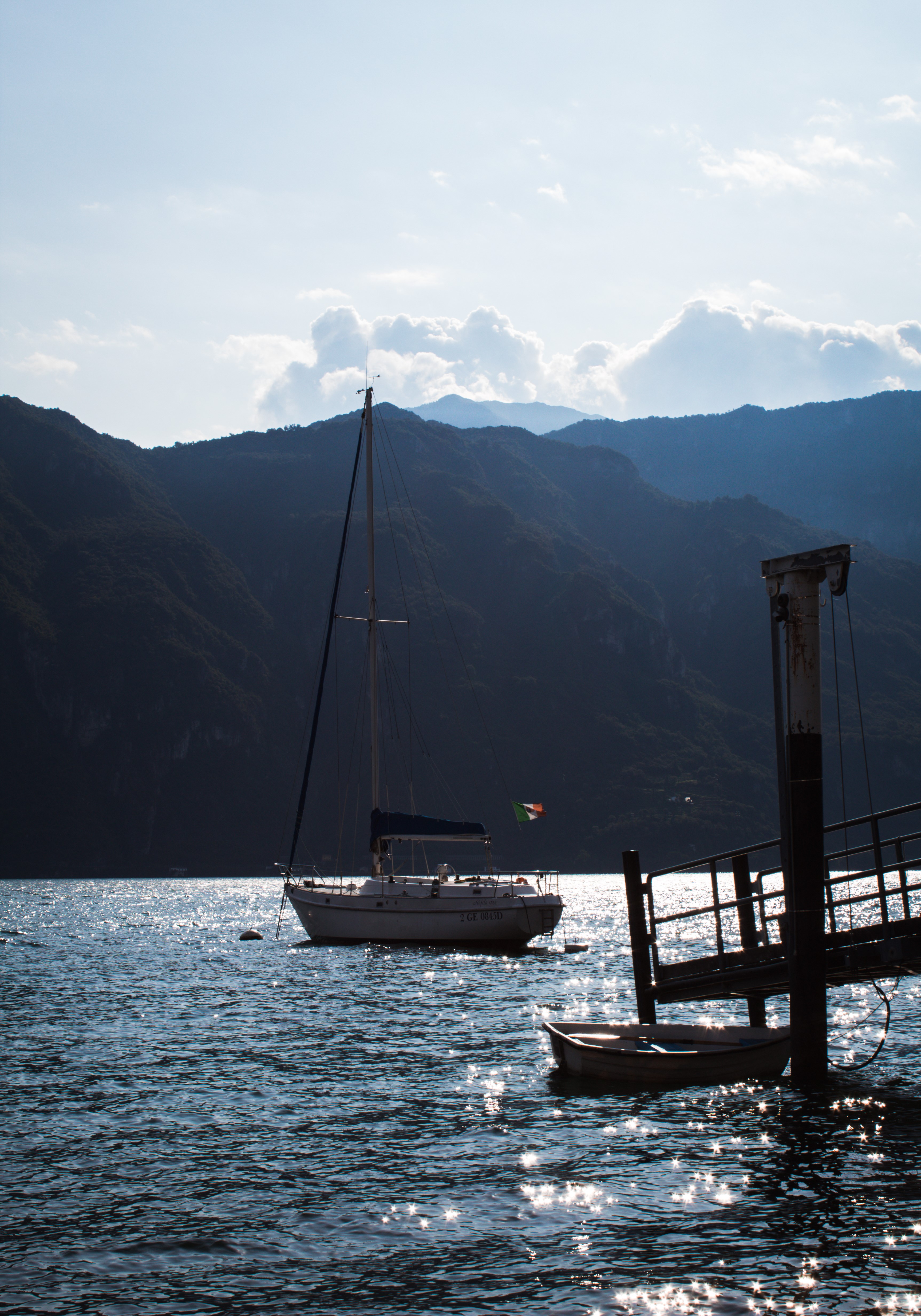 Sailboat on a lake with mountains in the background HD Phone Wallpaper