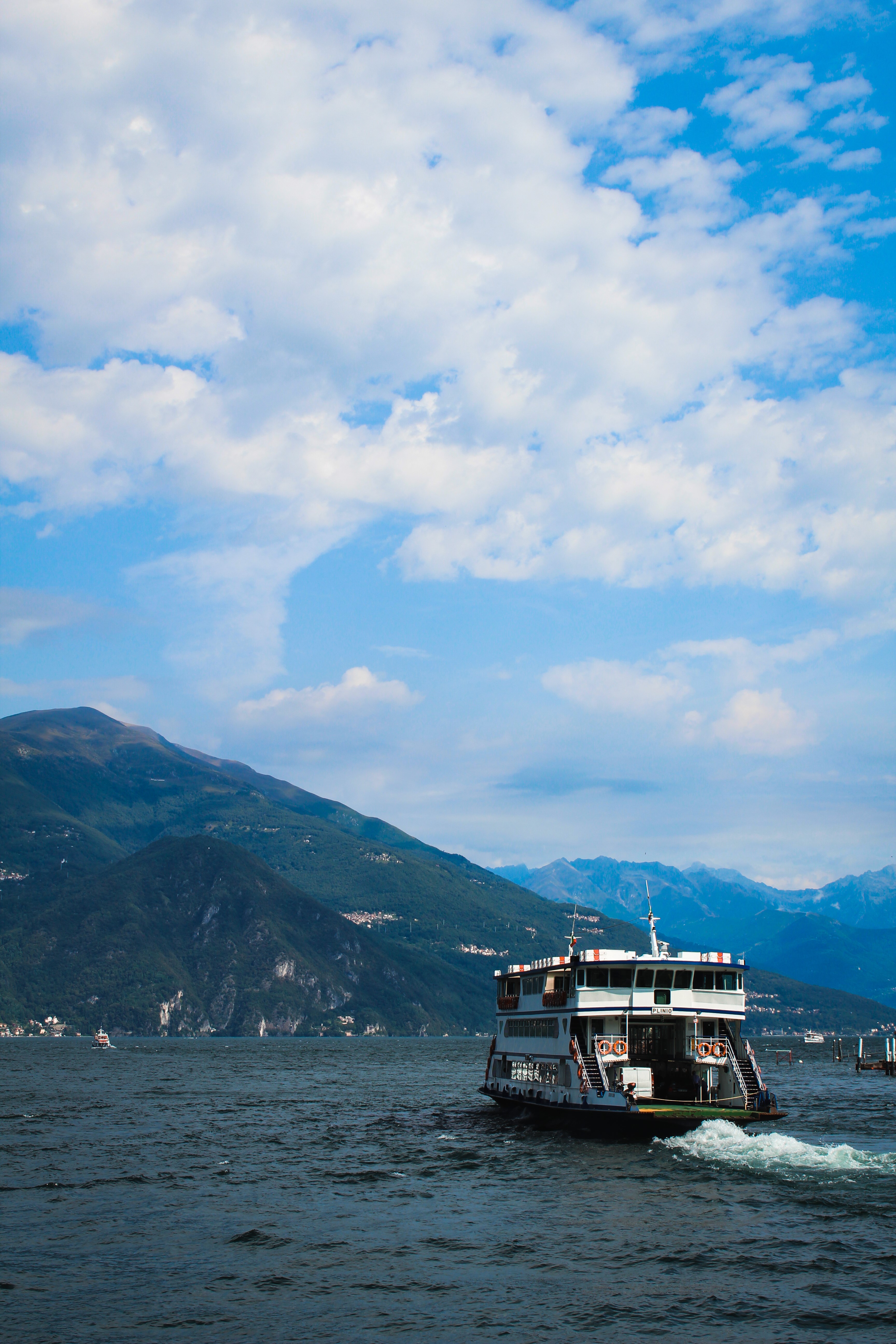 Ferry boat on a lake with mountains in the background HD Phone Wallpaper