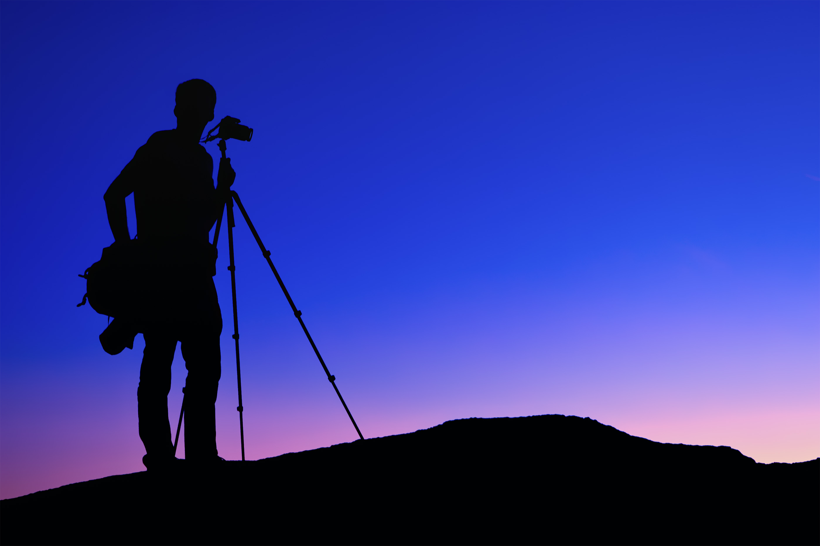 Silhouette of a photographer with a tripod at dusk HD Wallpaper
