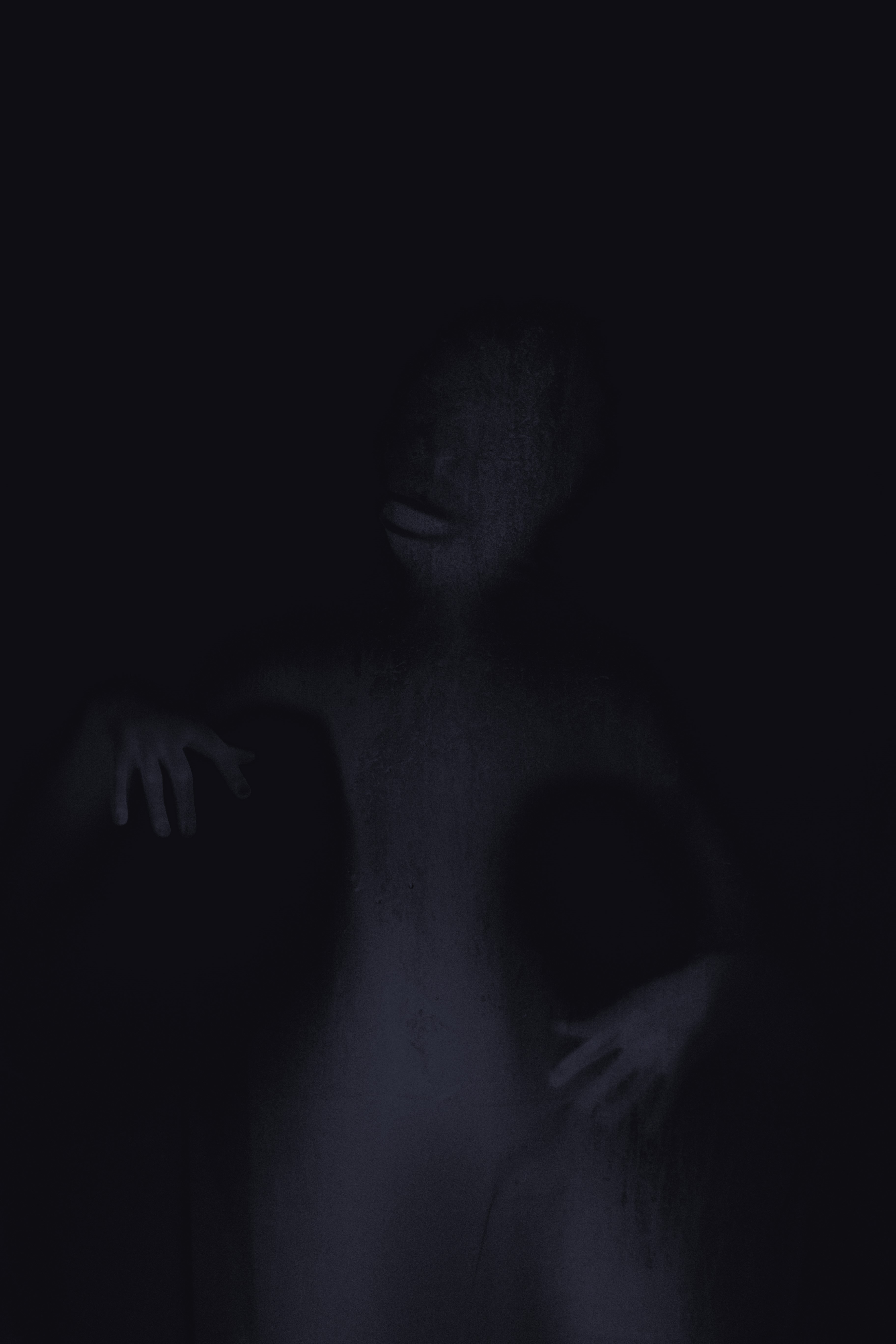 A shadowy figure with hands outstretched in the dark HD Phone Wallpaper