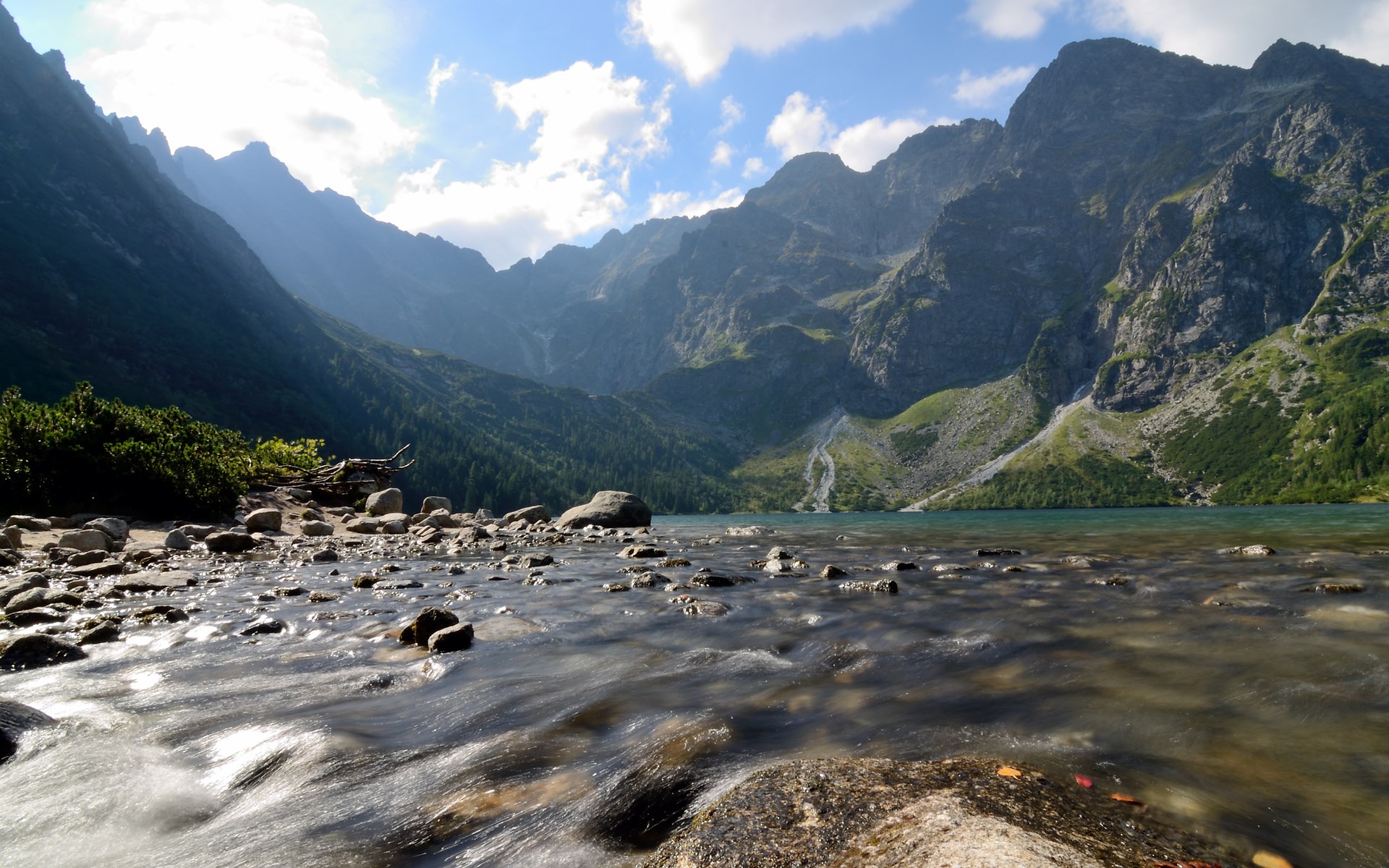 Mountain lake with rocky shore and flowing water HD Wallpaper