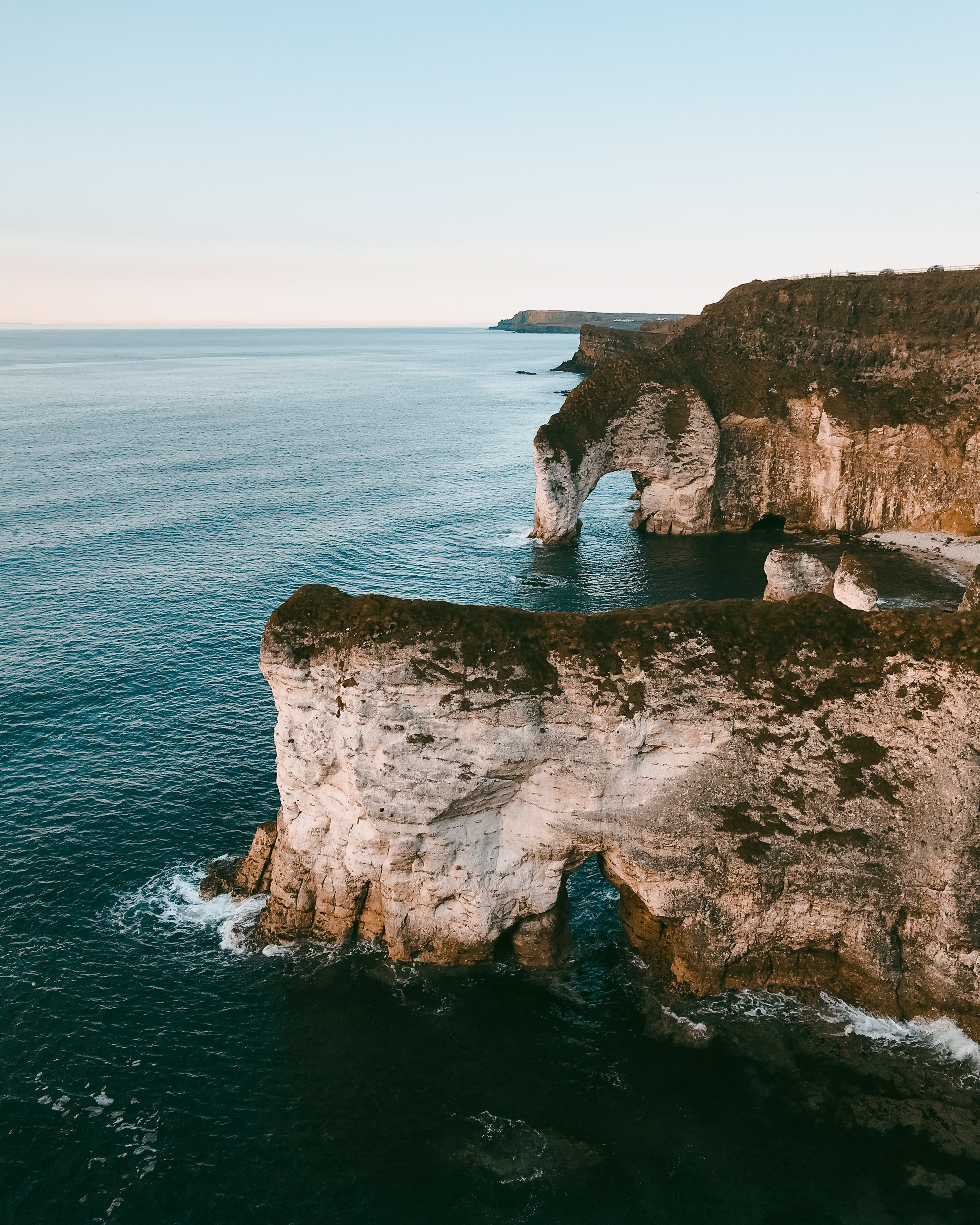 Coastal cliffs with sea arches from aerial view HD Phone Wallpaper