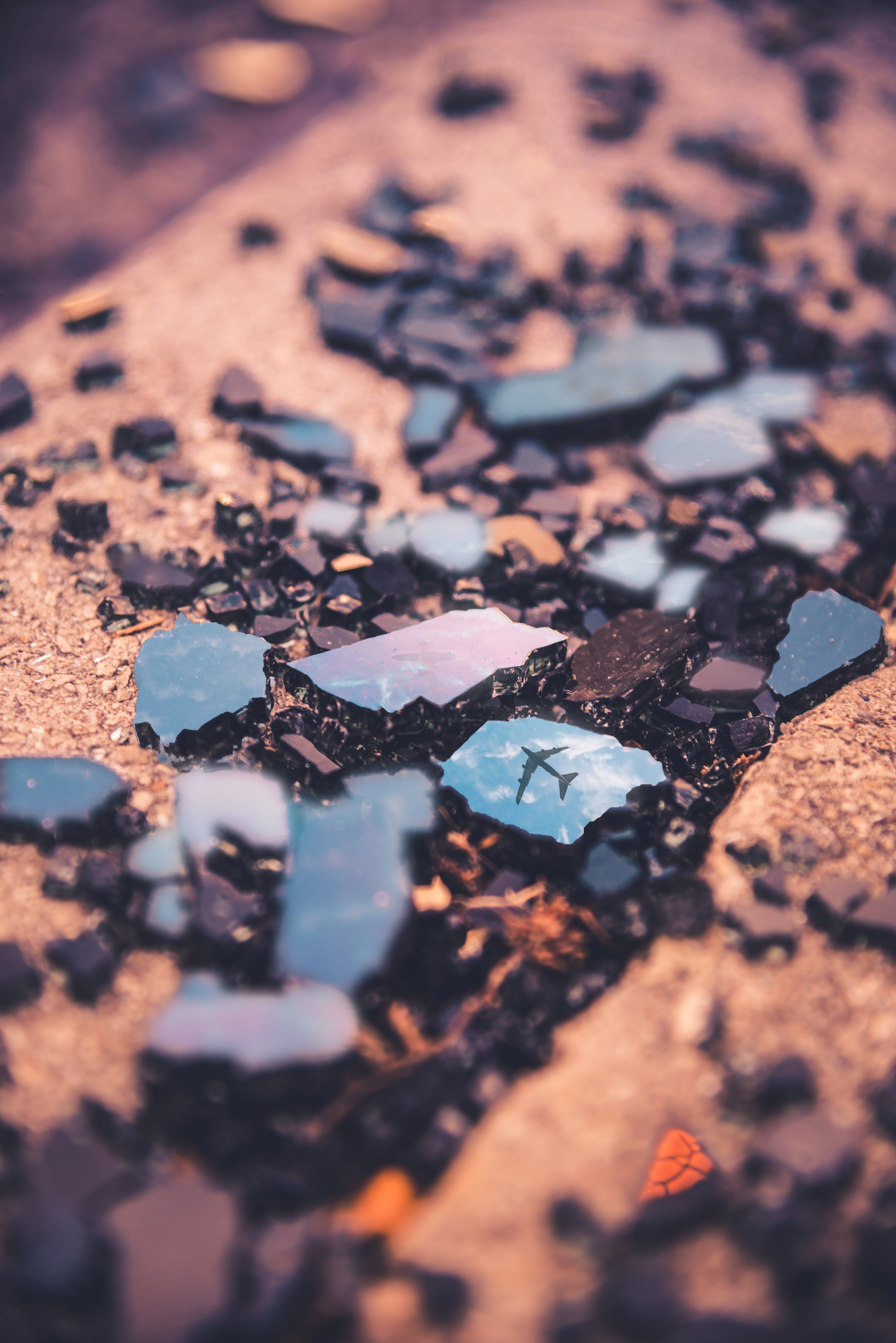 Broken glass reflecting an airplane in the sky HD Phone Wallpaper