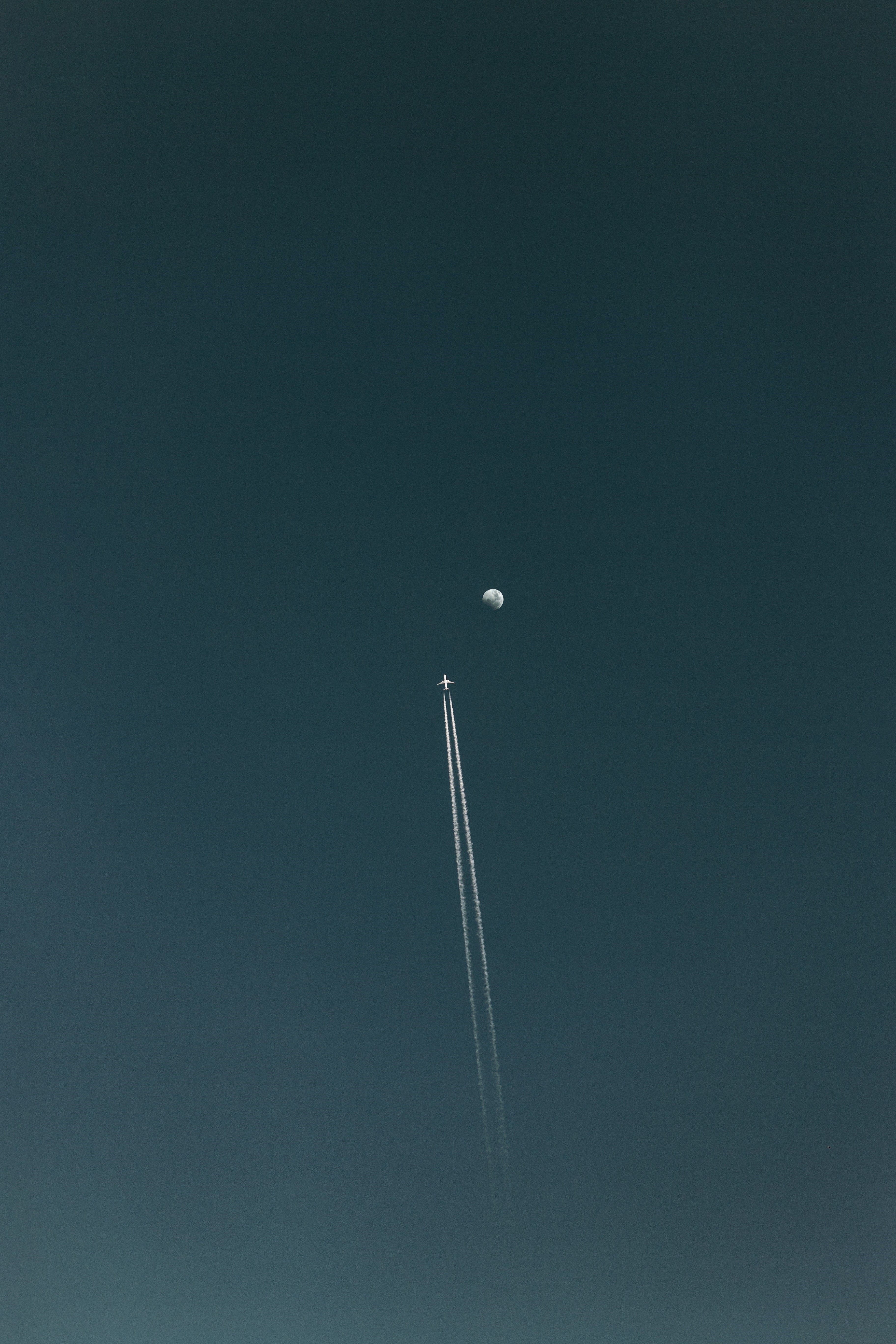 Airplane flying towards the Moon with contrails HD Phone Wallpaper