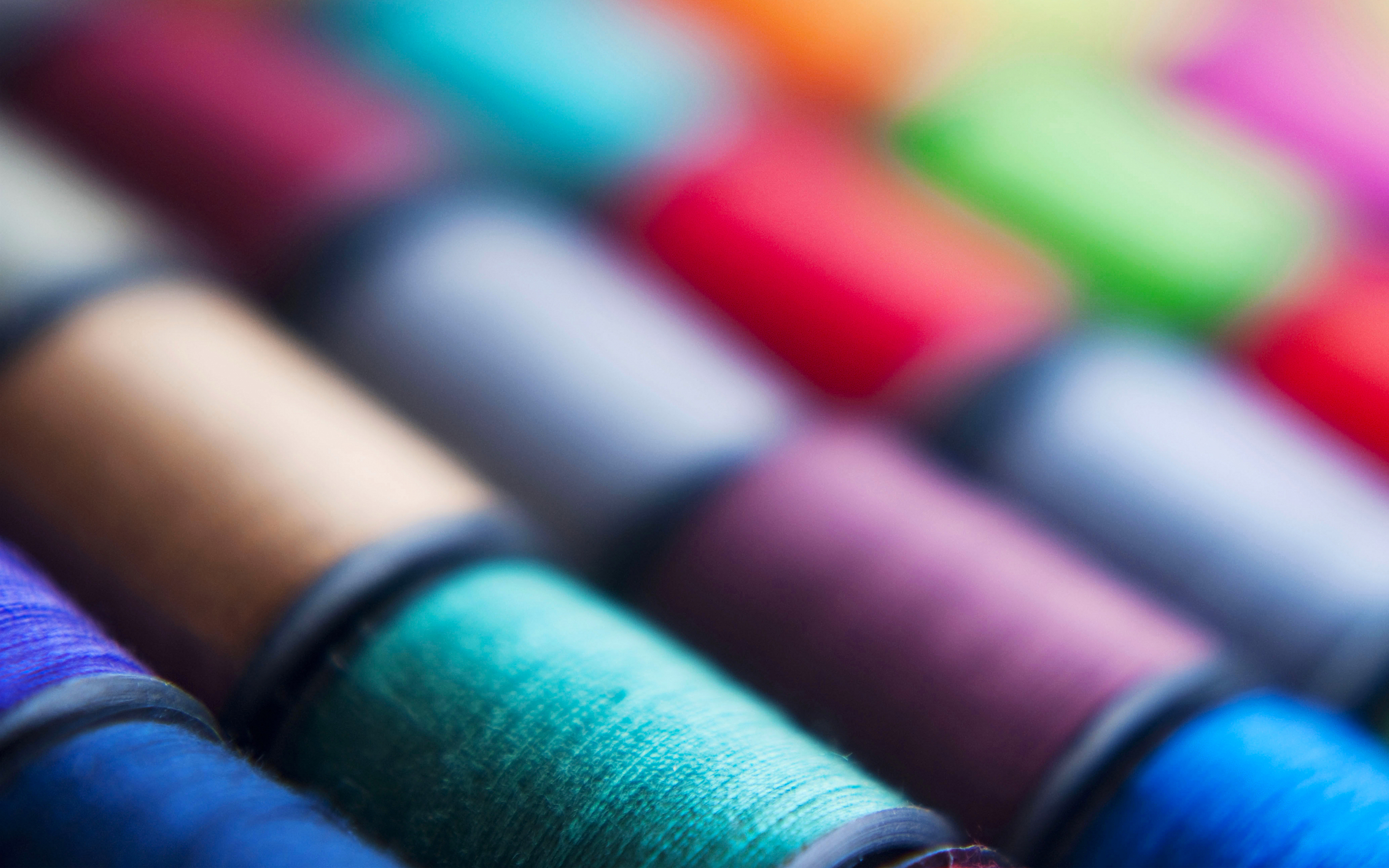 Macro view of colorful sewing threads on spools HD Wallpaper