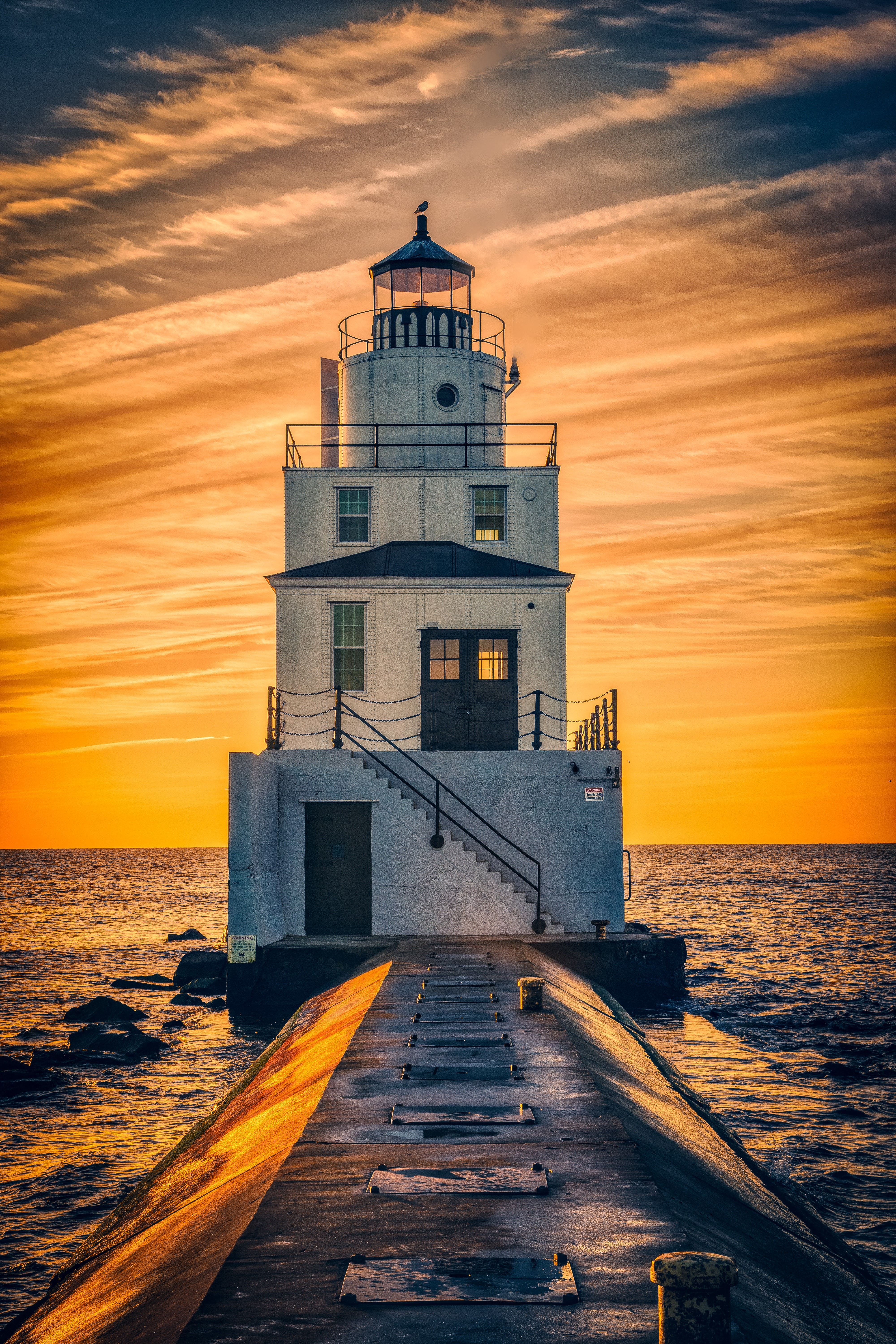 Lighthouse on a pier at sunset HD Phone Wallpaper