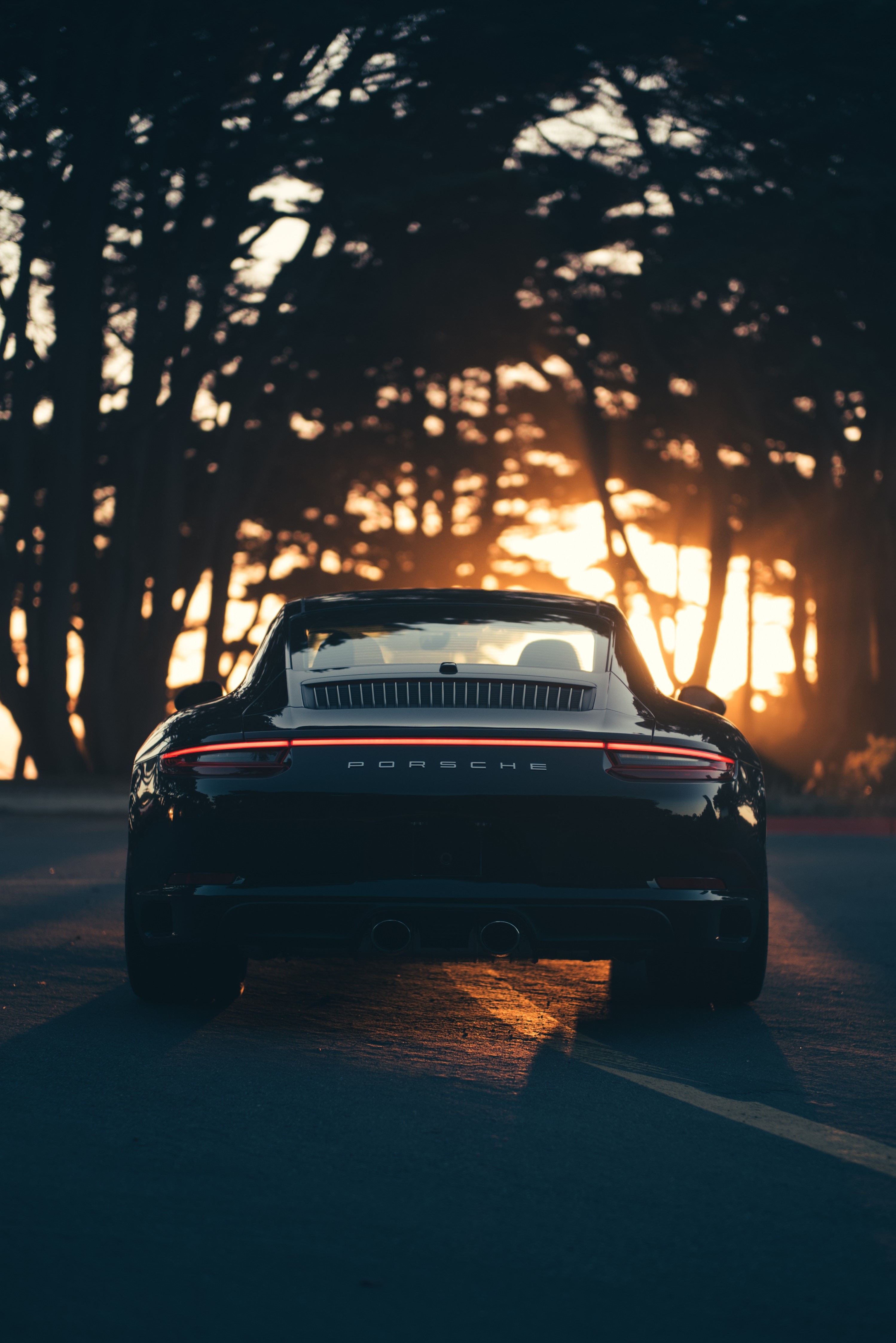Rear view of a black Porsche 911 at sunset HD Phone Wallpaper