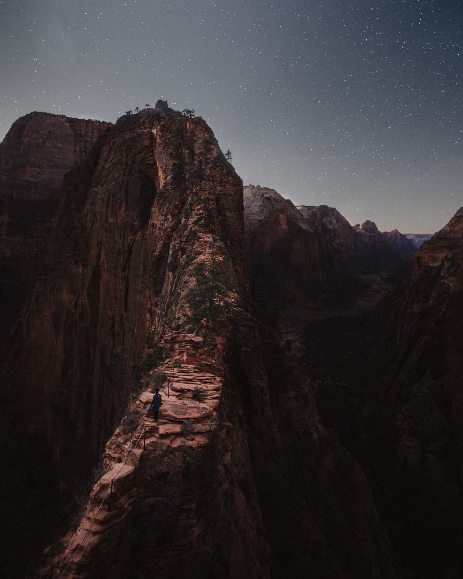 Hiker on narrow mountain ridge under starry sky HD Phone Wallpaper