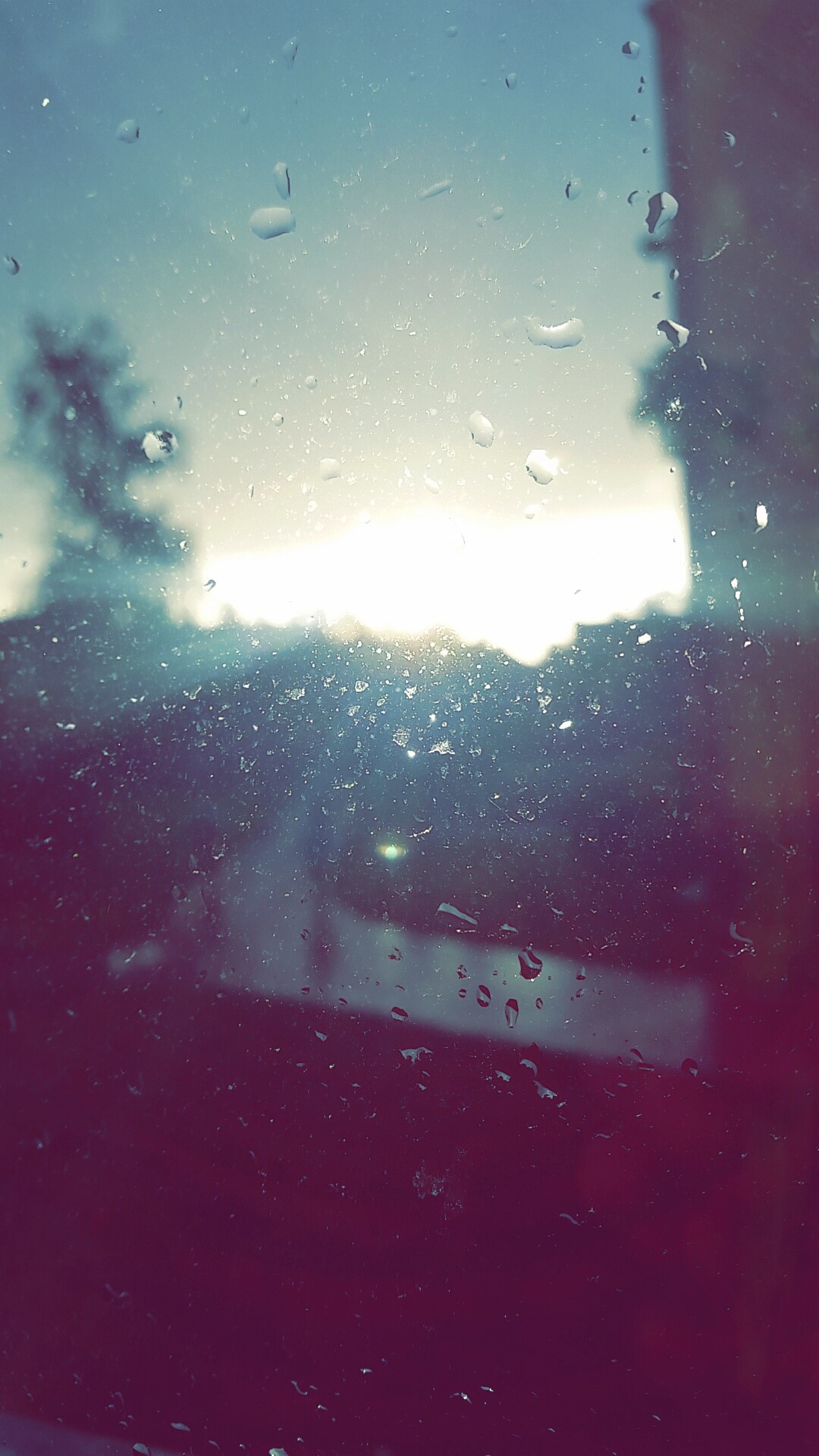 Raindrops on a window with a sunrise over a city HD Phone Wallpaper