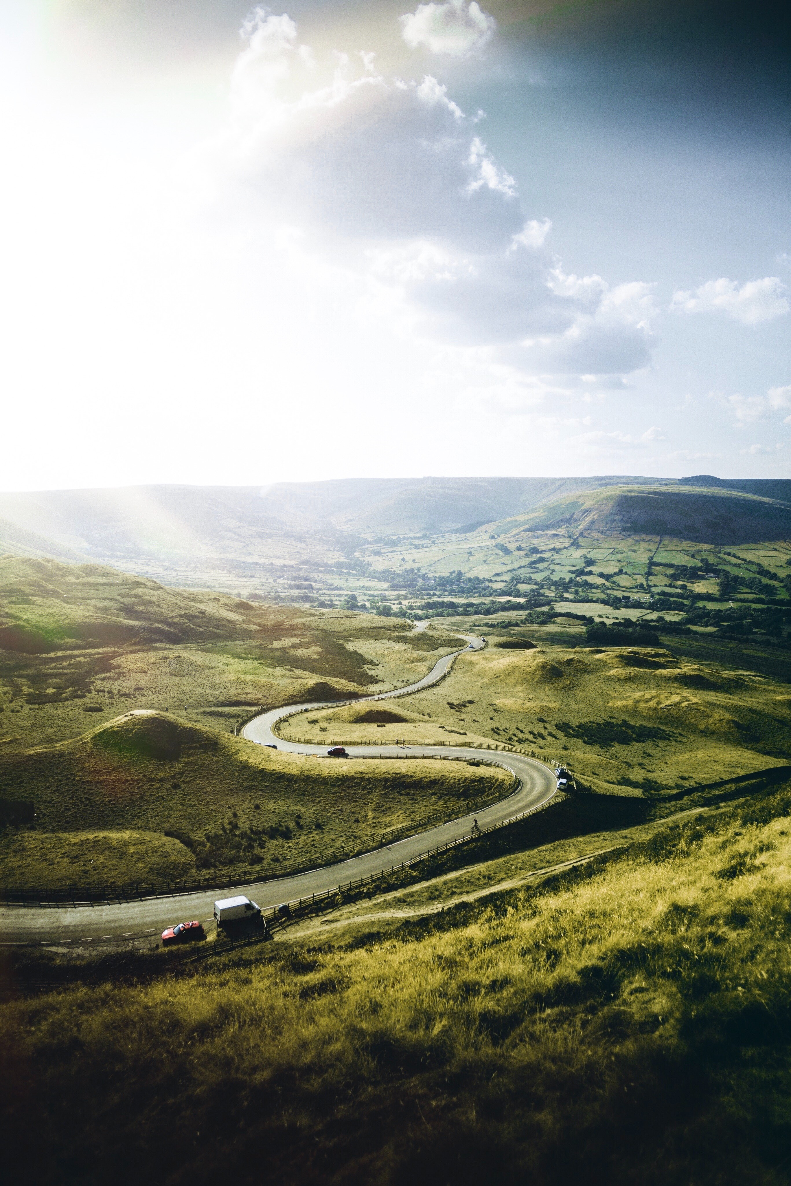 Winding road through rolling green hills in England HD Phone Wallpaper