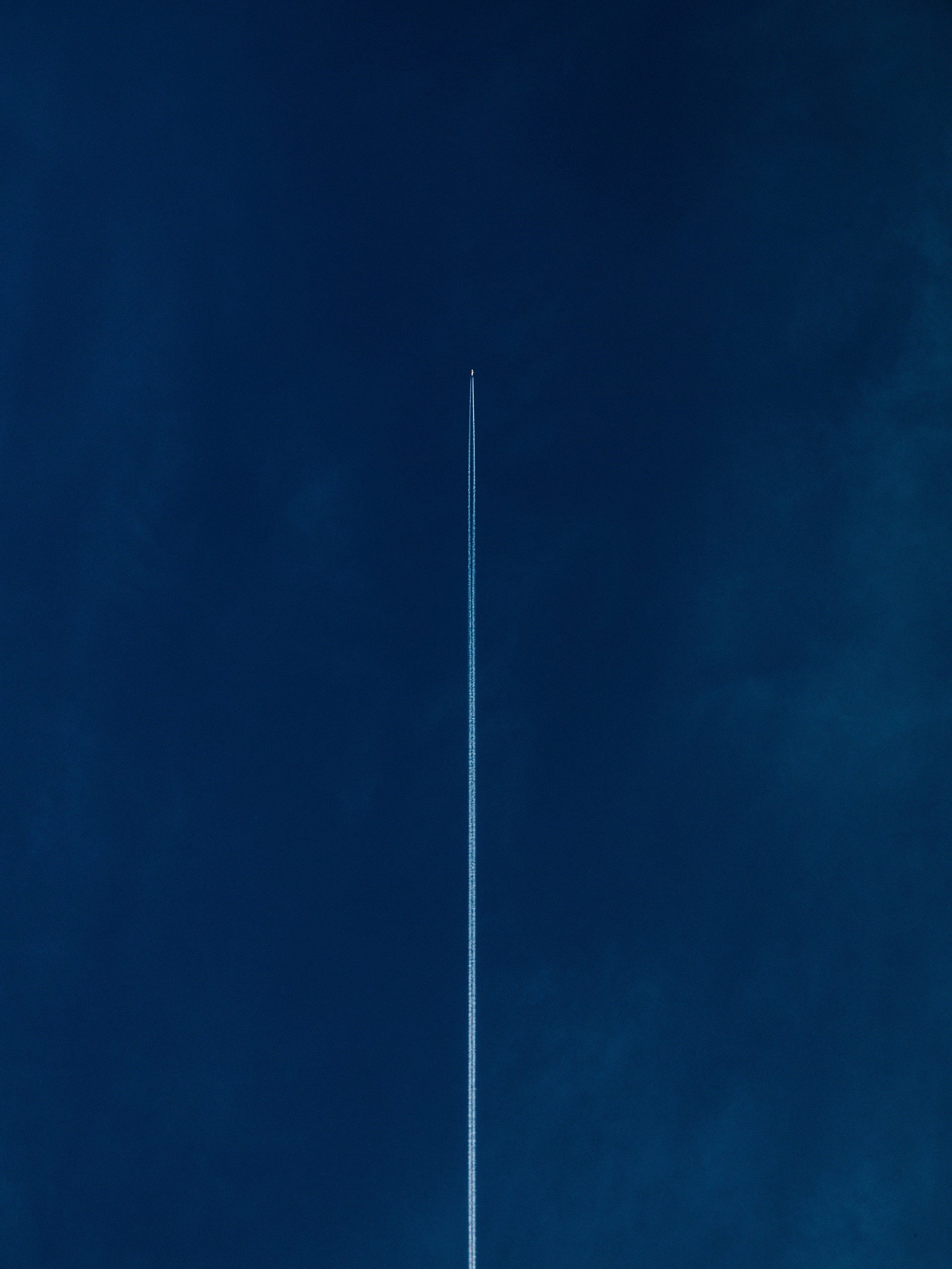 Airplane leaving contrails in a dark blue sky HD Phone Wallpaper