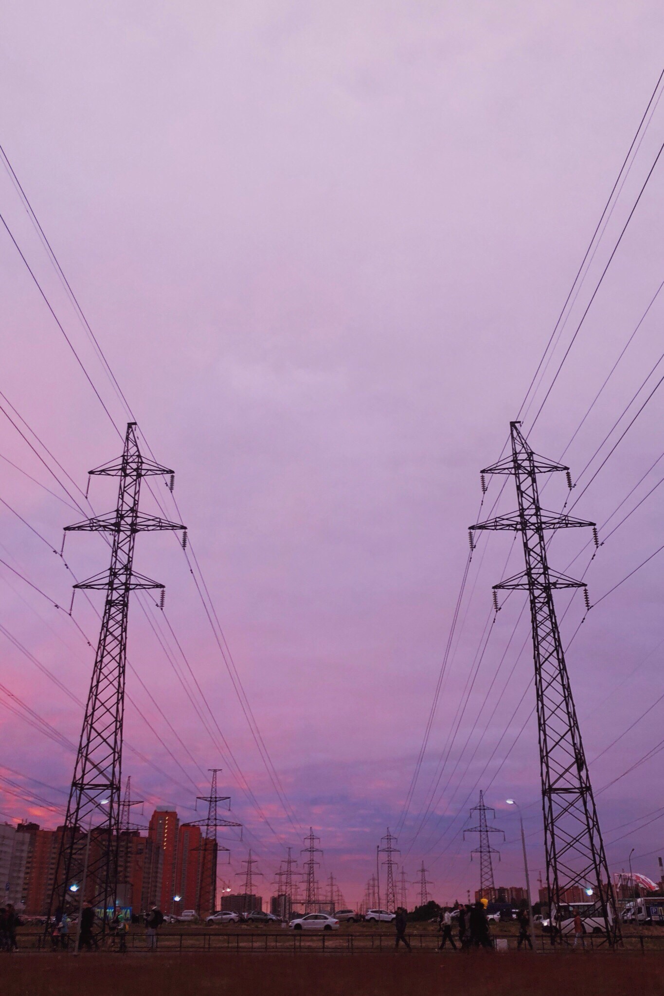 Power lines against a purple sunset sky with people and buildings HD Phone Wallpaper