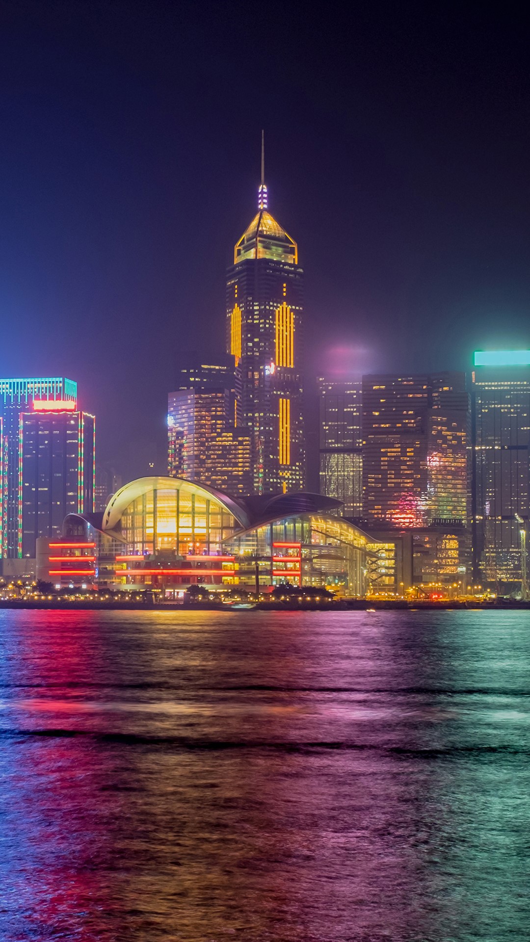 Hong Kong cityscape at night with illuminated skyscrapers and water reflection HD Phone Wallpaper