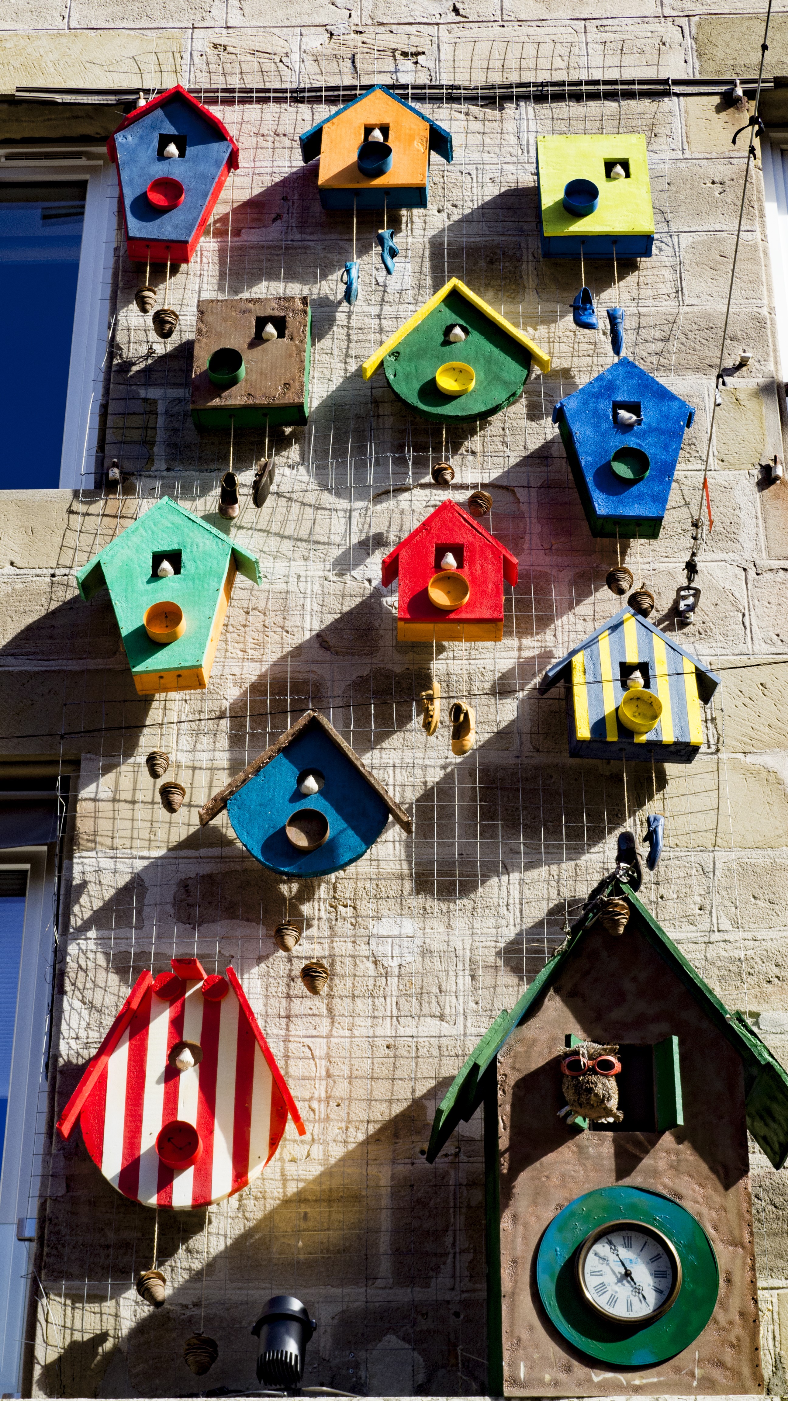 Colorful birdhouses on a brick wall HD Phone Wallpaper