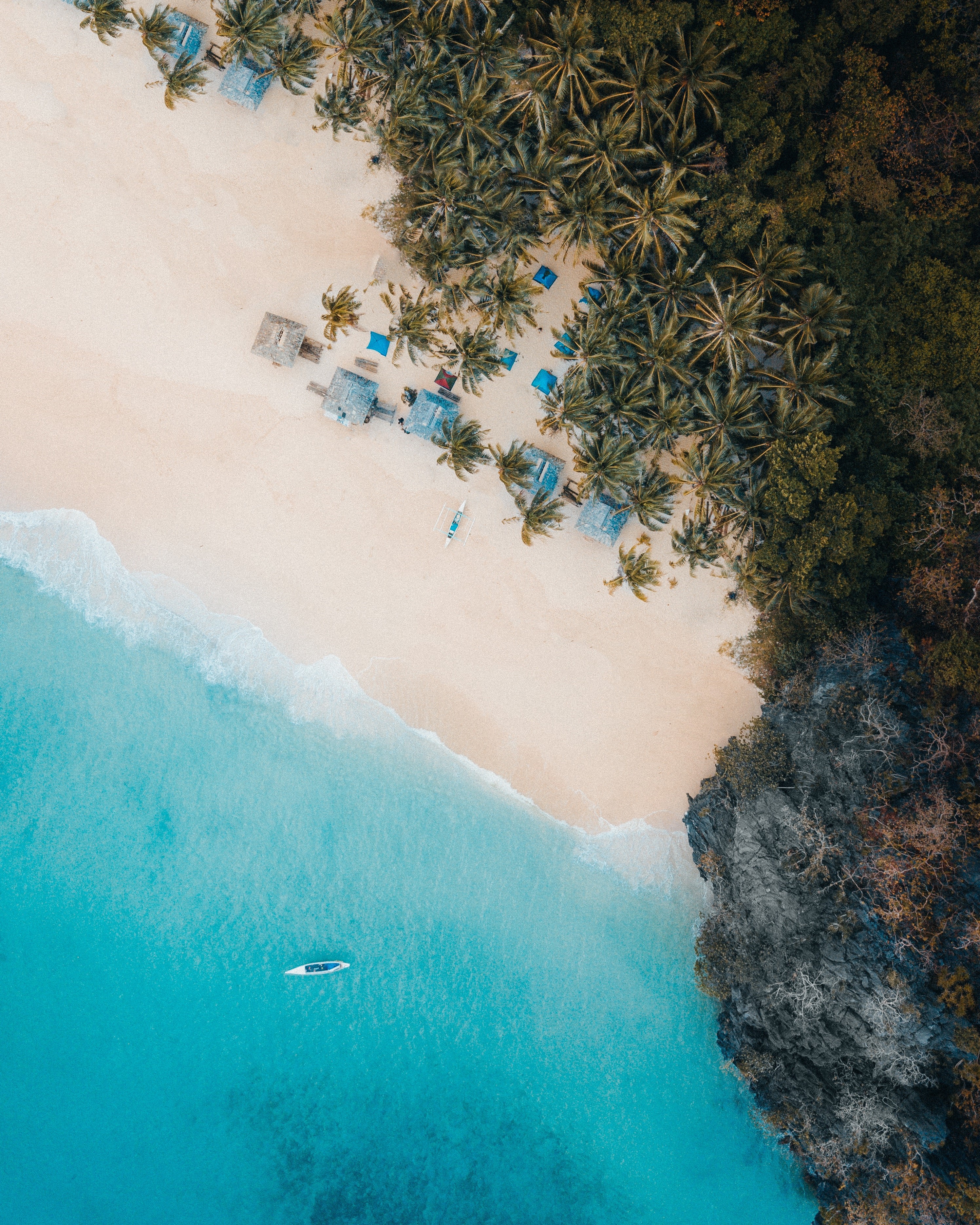 Aerial view of a tropical beach with palm trees and huts HD Phone Wallpaper