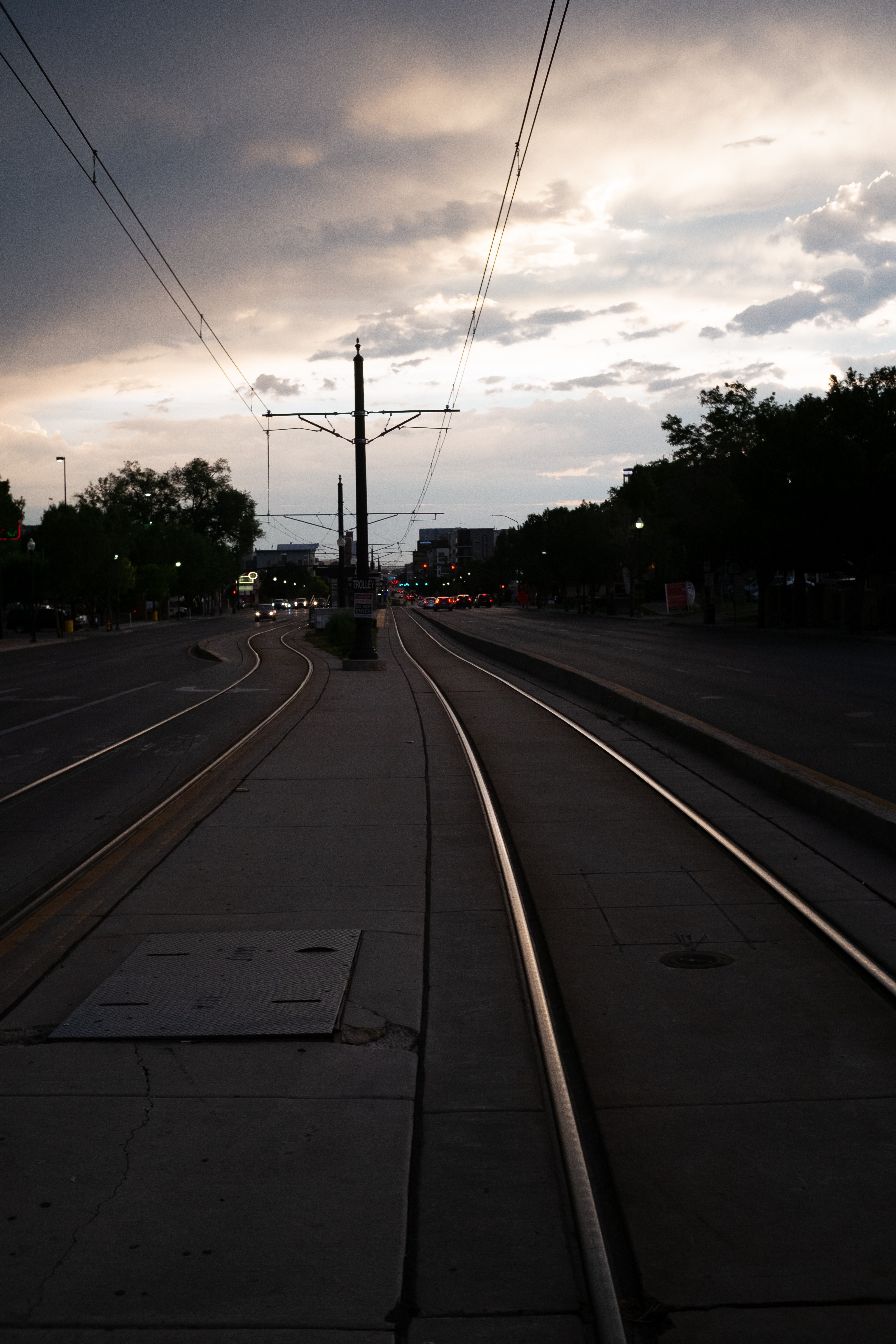 Street with tram tracks and overhead wires at dusk HD Phone Wallpaper