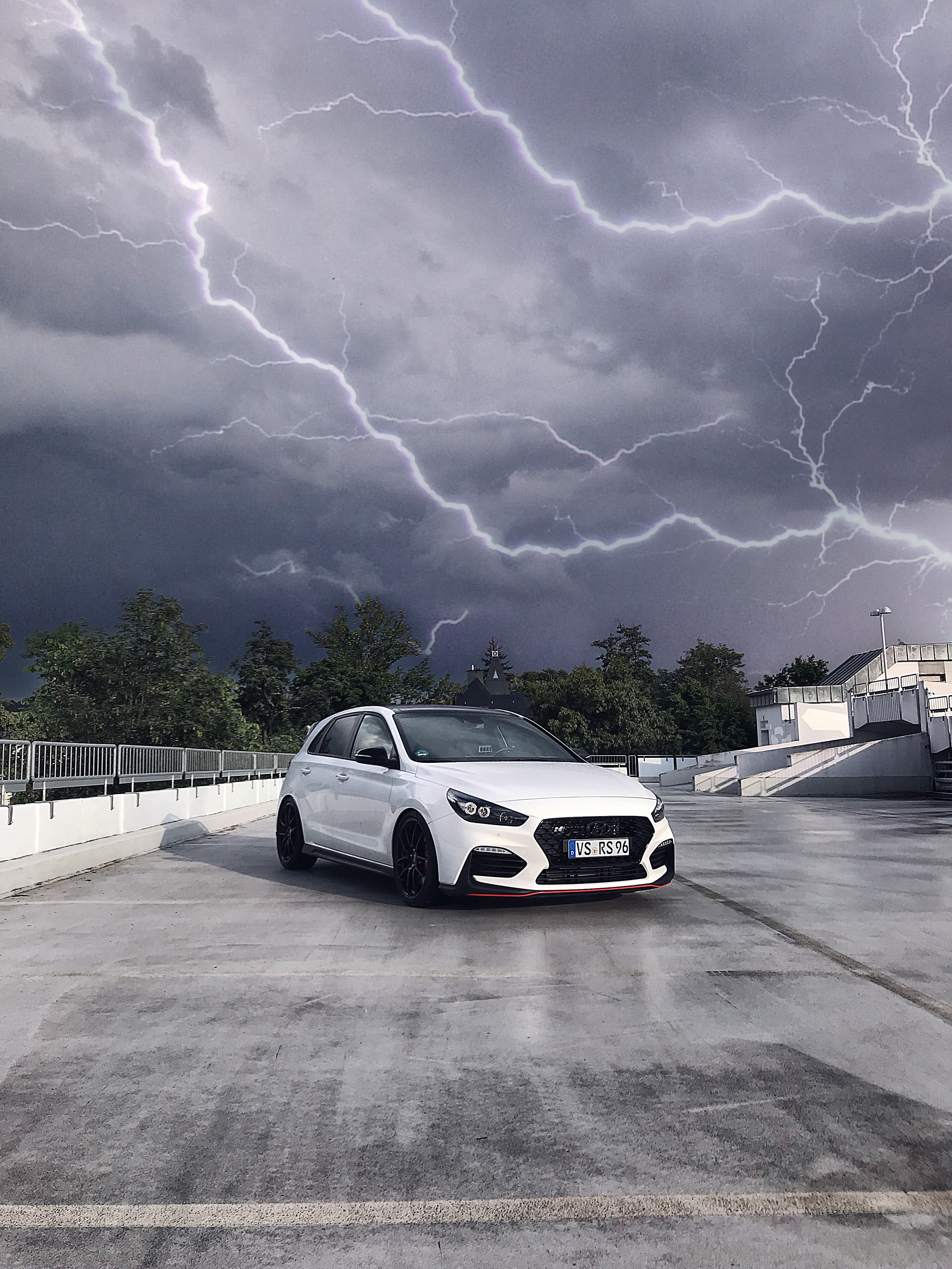 White Hyundai i30N hot hatch on a parking lot during a thunderstorm HD Phone Wallpaper