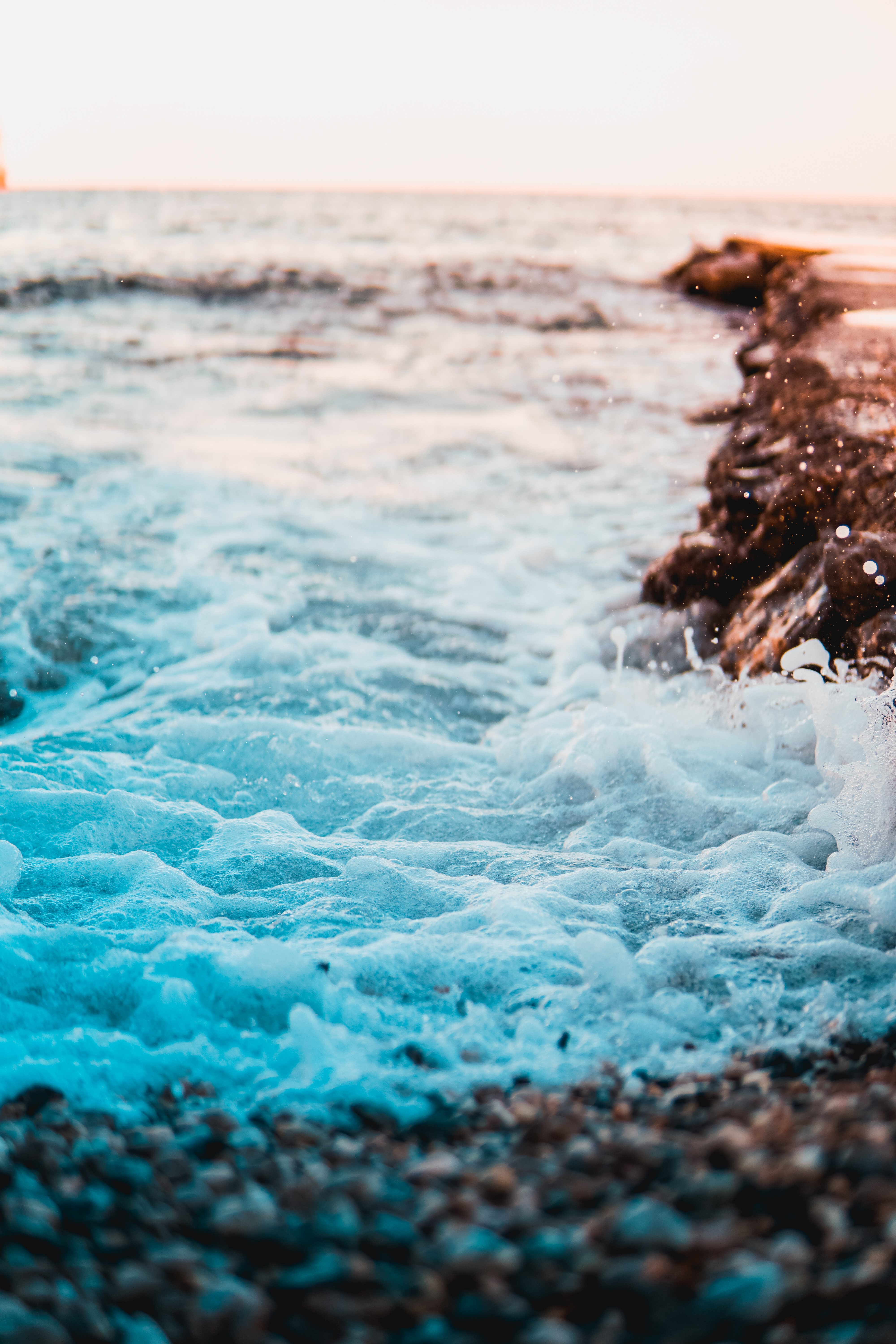Cyan Waves Crashing on Rocky Coastline HD Phone Wallpaper