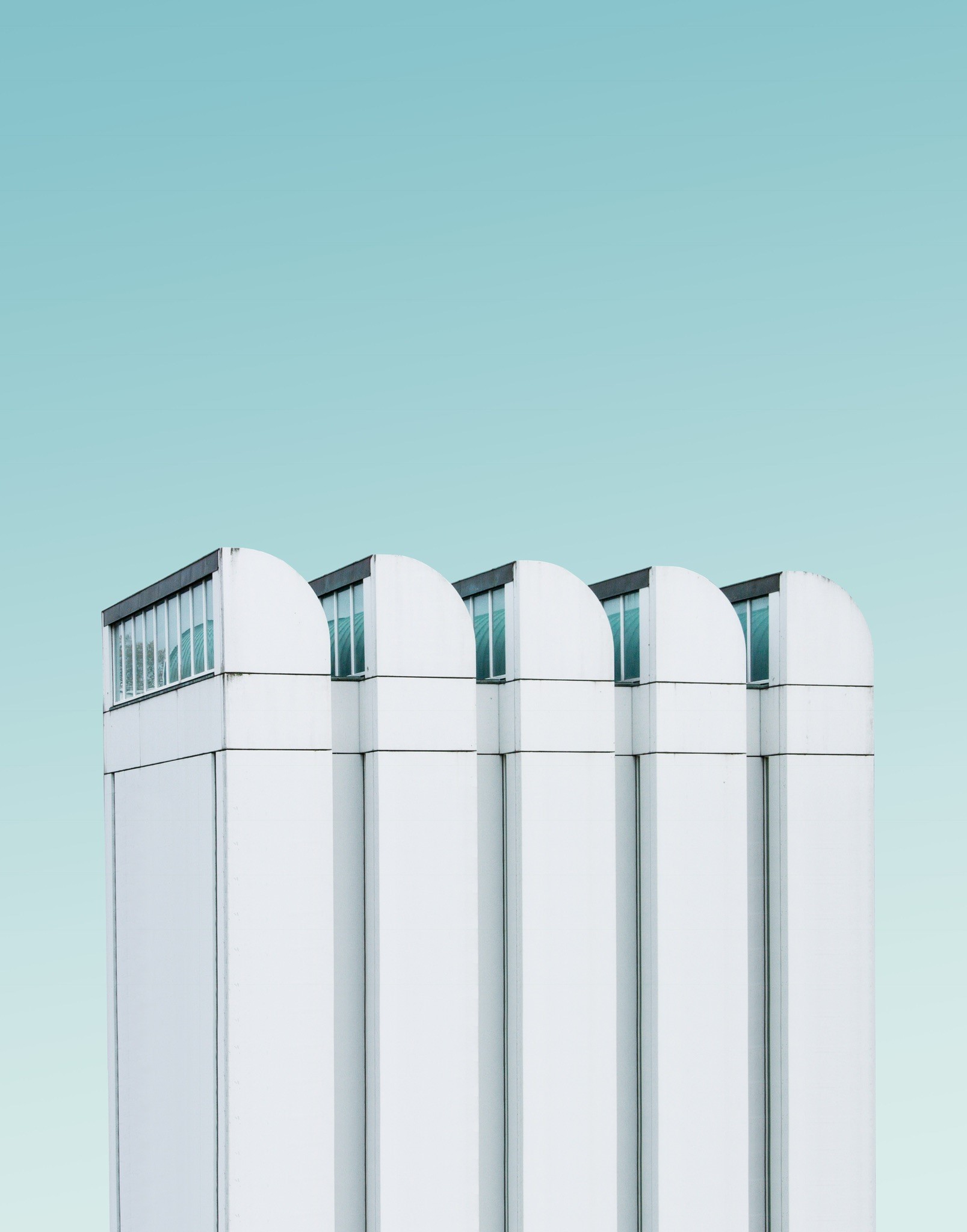Modern white building with arched windows against a blue sky HD Phone Wallpaper