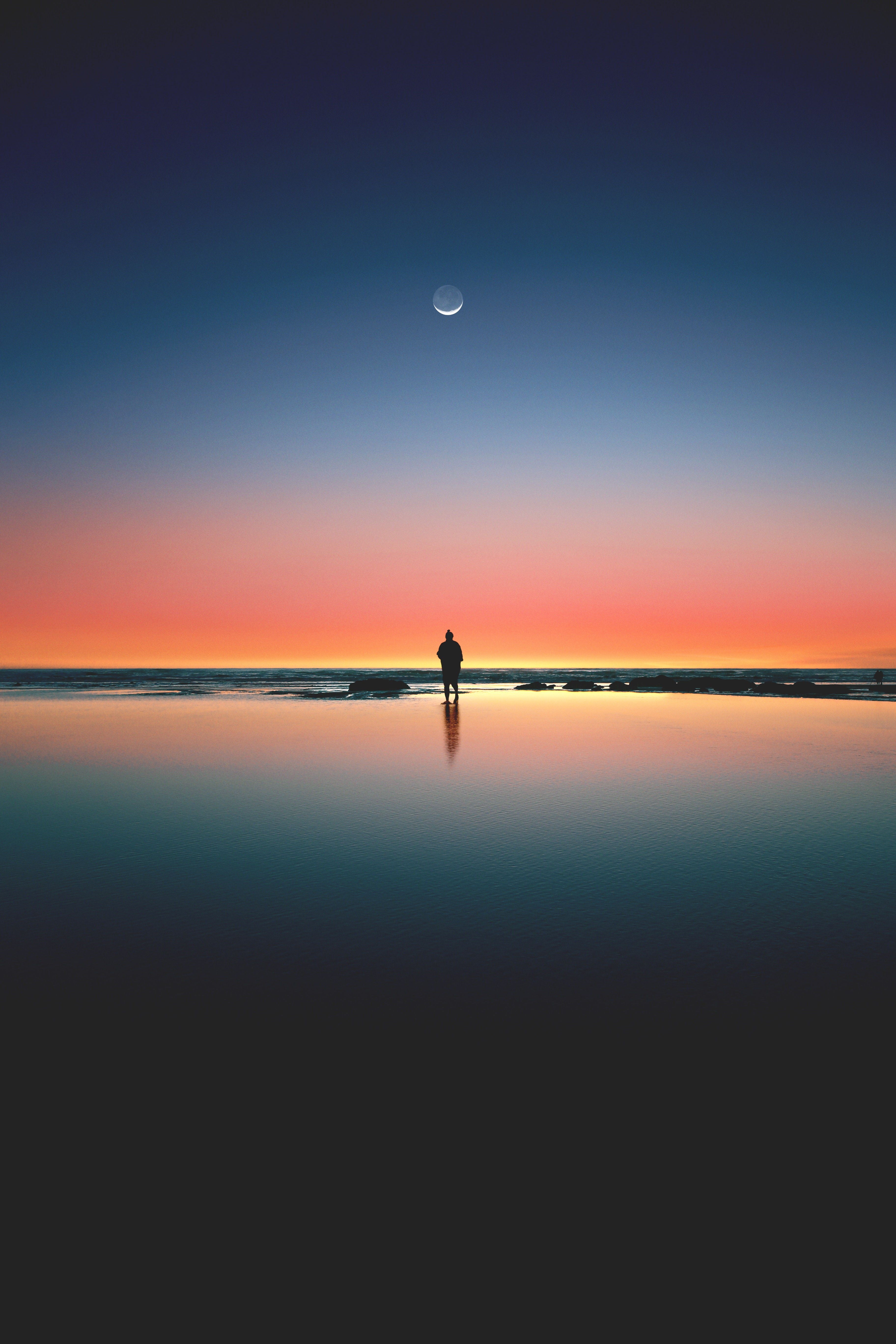 Silhouette of a person on a beach at sunset with a crescent moon HD Phone Wallpaper
